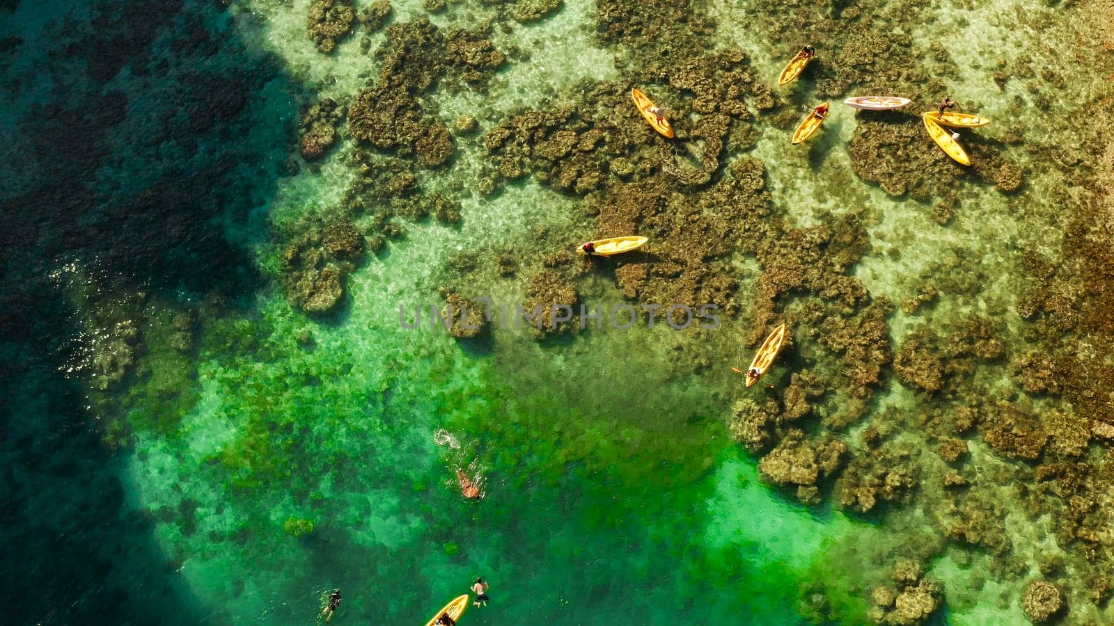 Tourists on the kayak in the lagoon with clear water, aerial view. Snorkeling and kayaking in the lagoon. Small lagoon with turquoise water. El nido, Philippines, Palawan. Summer and travel vacation concept.