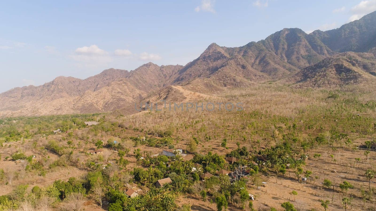 aerial view agricultural land and mountains in countryside. mountain range with high cliffs mountain slopes covered with vegetation bali, indonesia