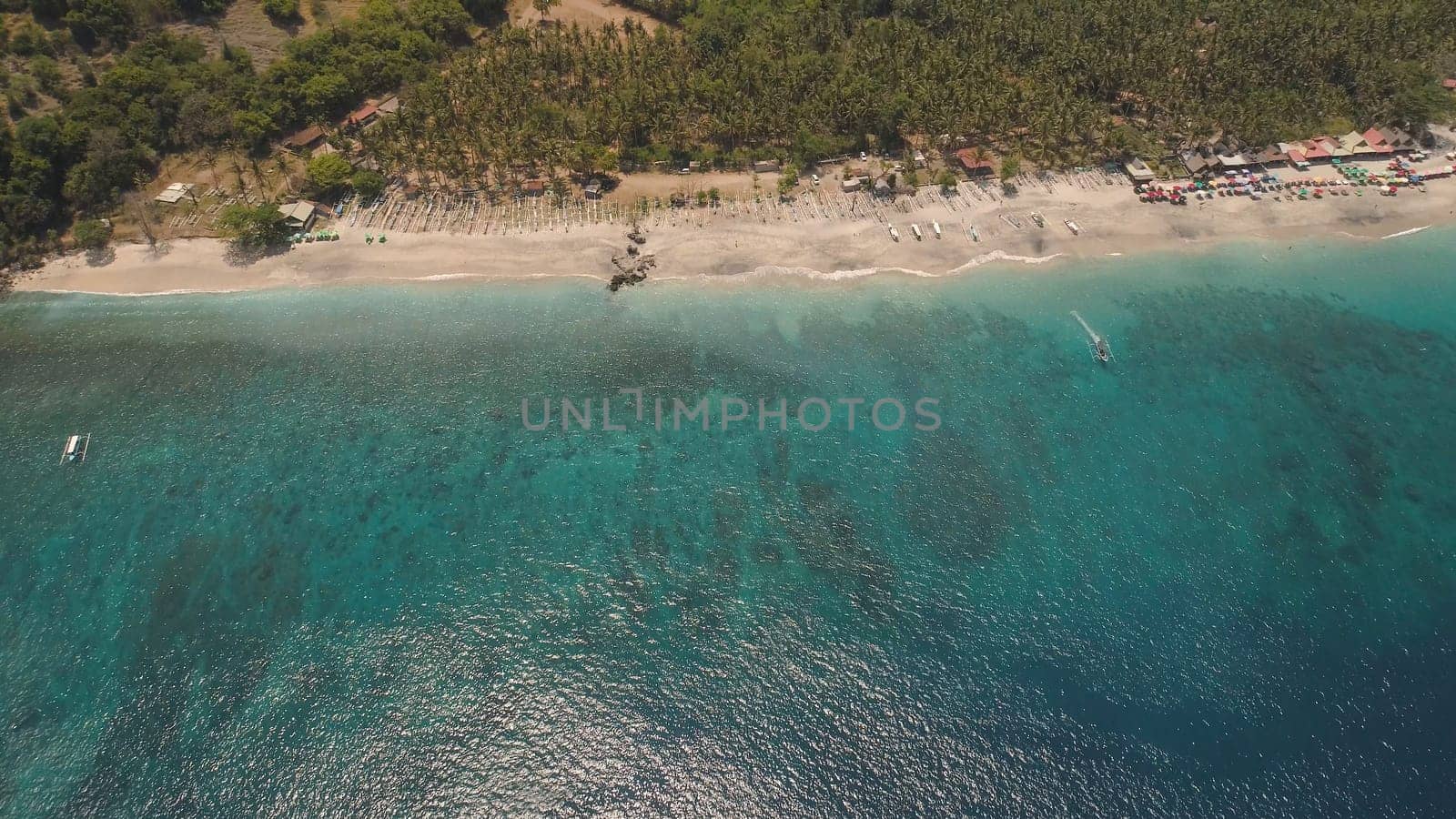 sandy beach with palm trees in tropical resort. aerial seascape sand beach with turquoise water. Seascape, ocean and beautiful beach.Travel concept. Indonesia, Bali