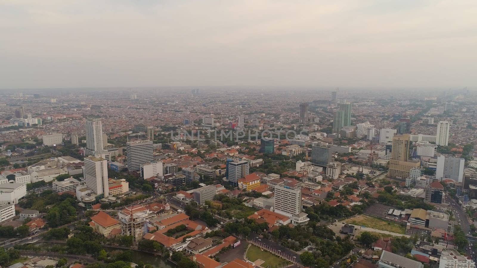 Aerial cityscape modern city Surabaya with skyscrapers, buildings and houses. sunset in city skyline with skyscrapers and business centers Surabaya capital city east java, indonesia