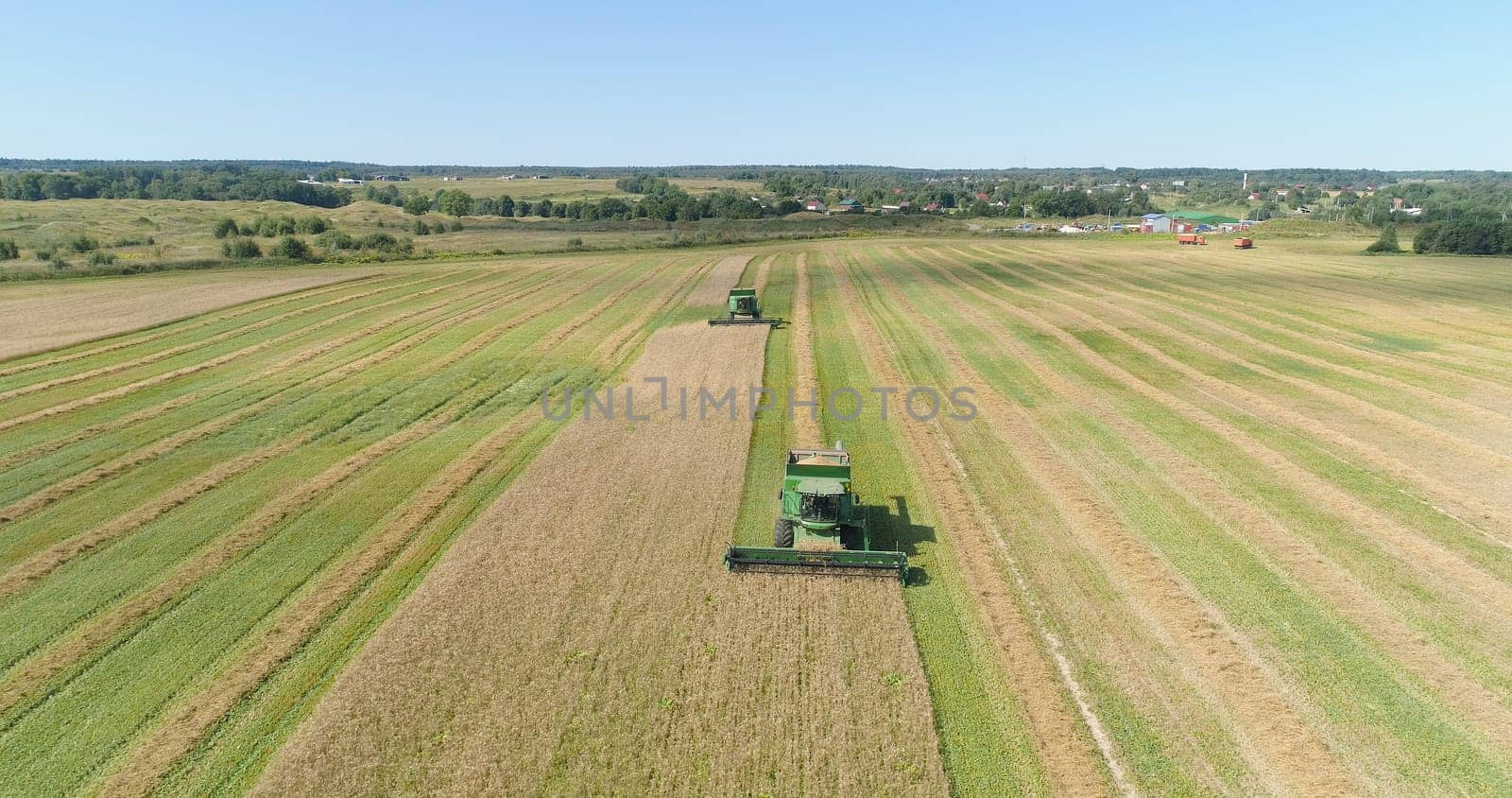 Combine harvester at work harvesting field wheat. Aerial view Combine harvester mows ripe spikelets, barley, rye. Combine harvester harvest ripe wheat on a farm.