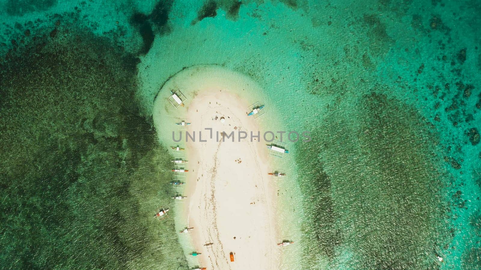 Sandy white island with beach and sandy bar in the turquoise atoll water, aerial drone.Tropical island and coral reef. Naked Island, Siargao.