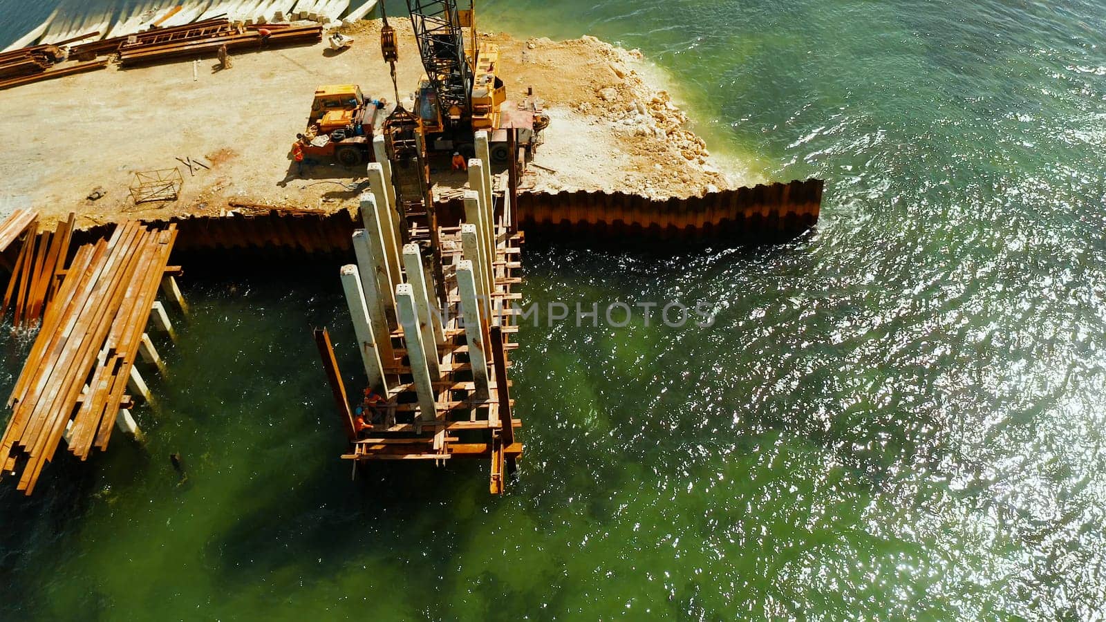Pile driving machine in construction site.The bridge under construction across the bay and construction equipment with workers on the bridge. Siargao, Philippines.