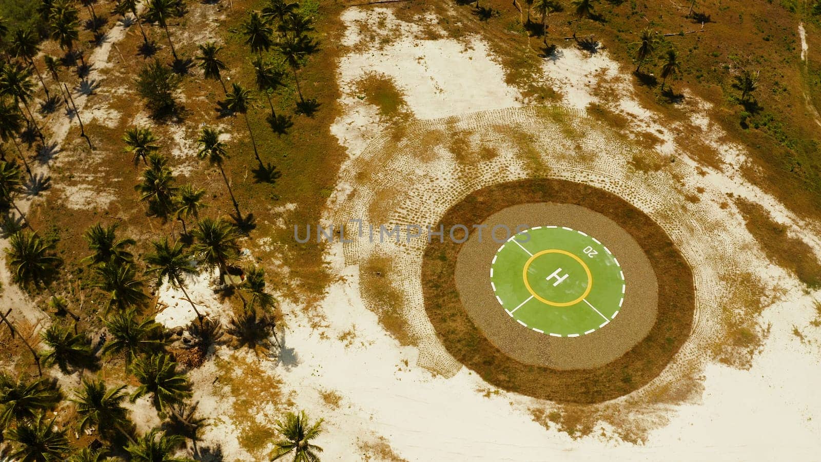 Helipad among the palm trees on a tropical island from above. Helicopter landing site. Bugsuk island, Balabac, Palawan