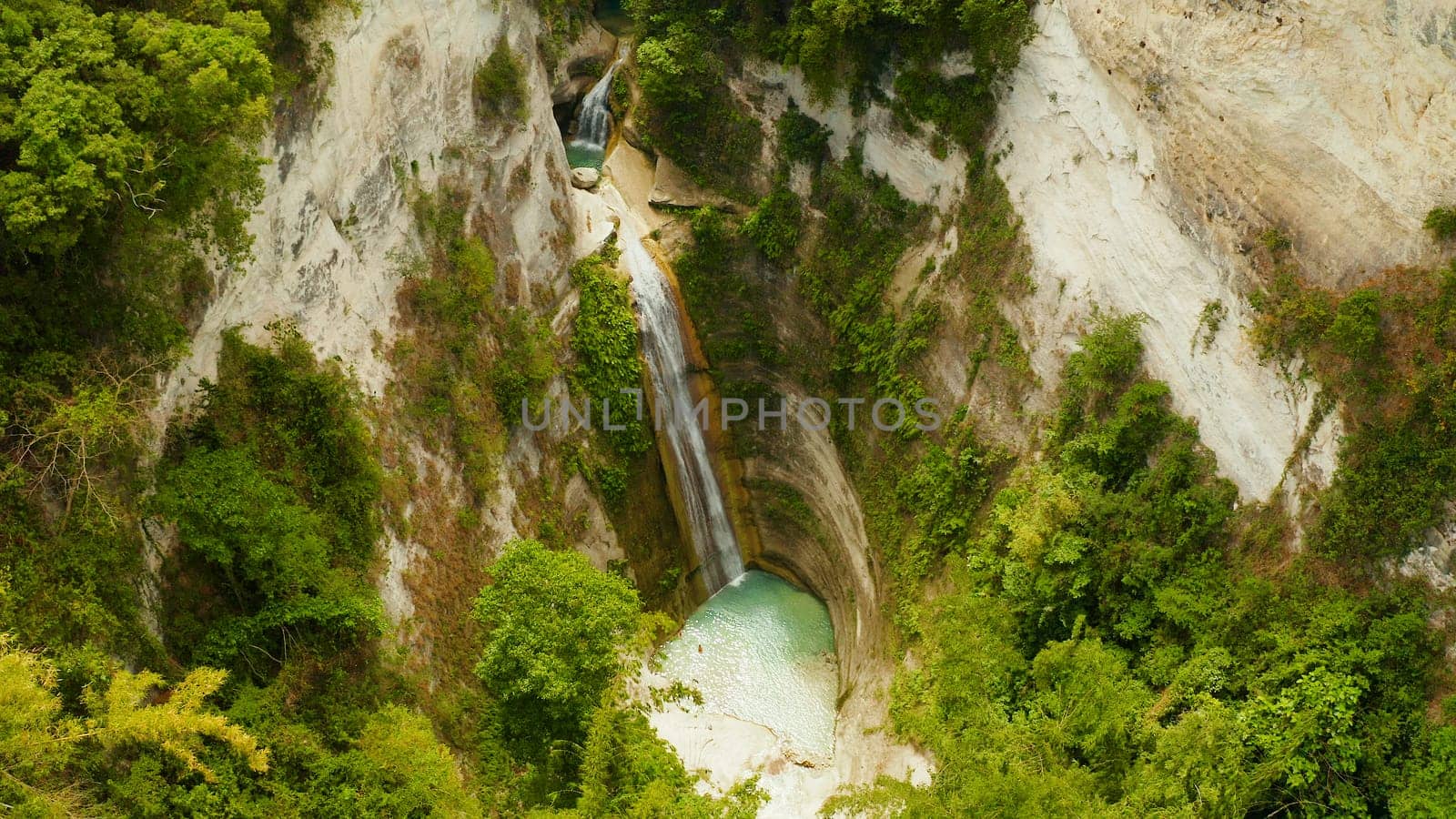 Beautiful waterfall in green forest, top view. Tropical Dao Falls in mountain jungle, Philippines, Cebu. Waterfall in the tropical forest.
