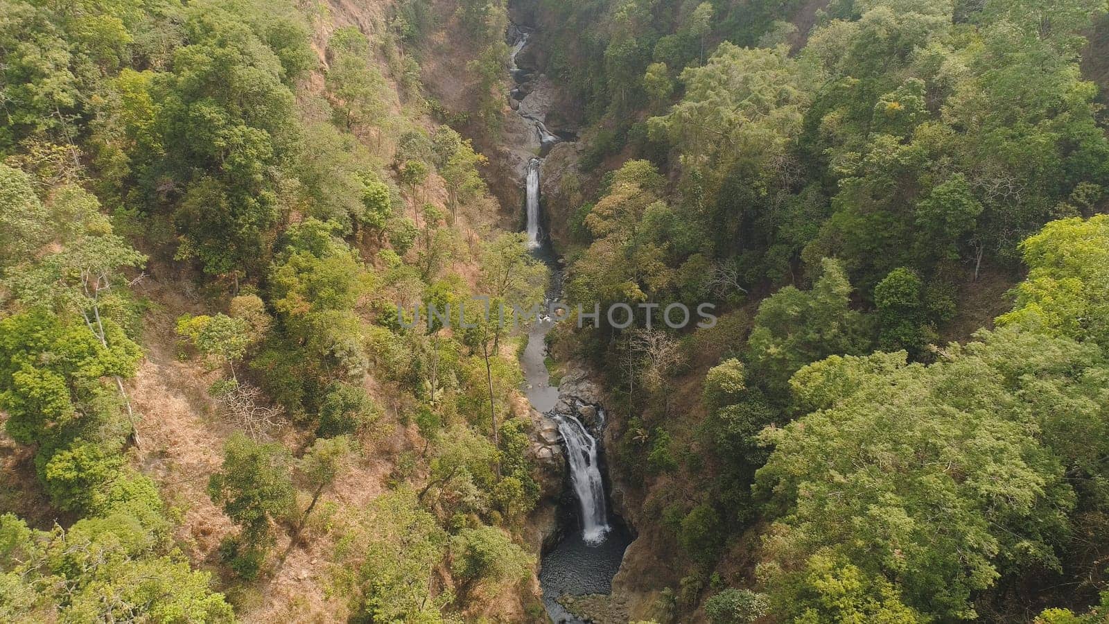waterfall in tropical forest. aerial view hidden waterfall rainforest in Java Indonesia. forest with green, lush vegetation.