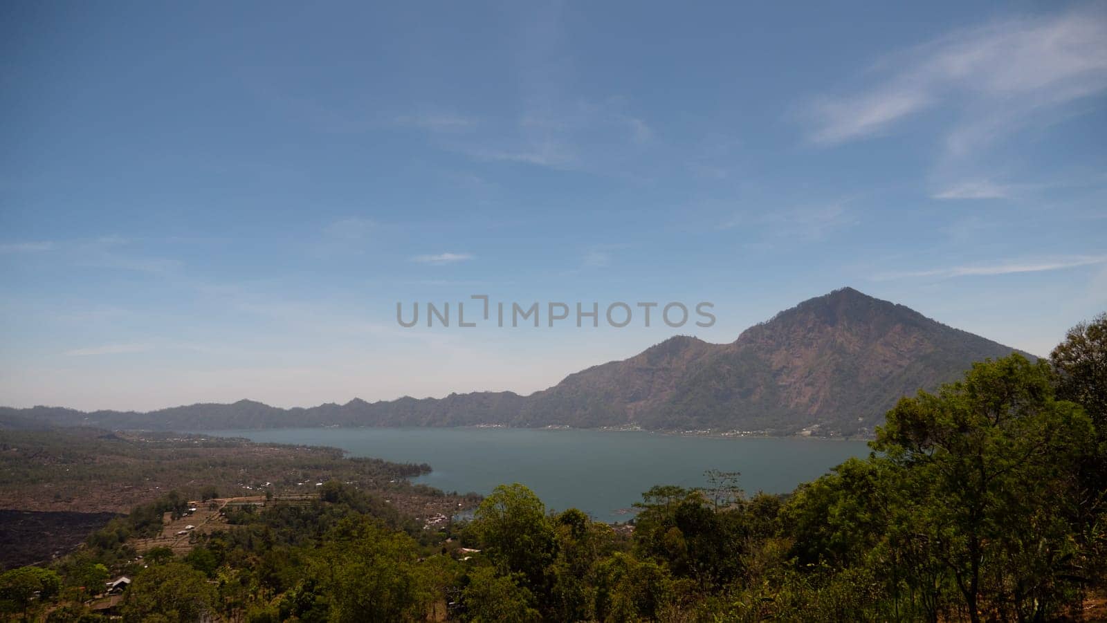 mountain landscape crater lake batur mountains with trees against blue sky Bali, Indonesia. Travel concept.