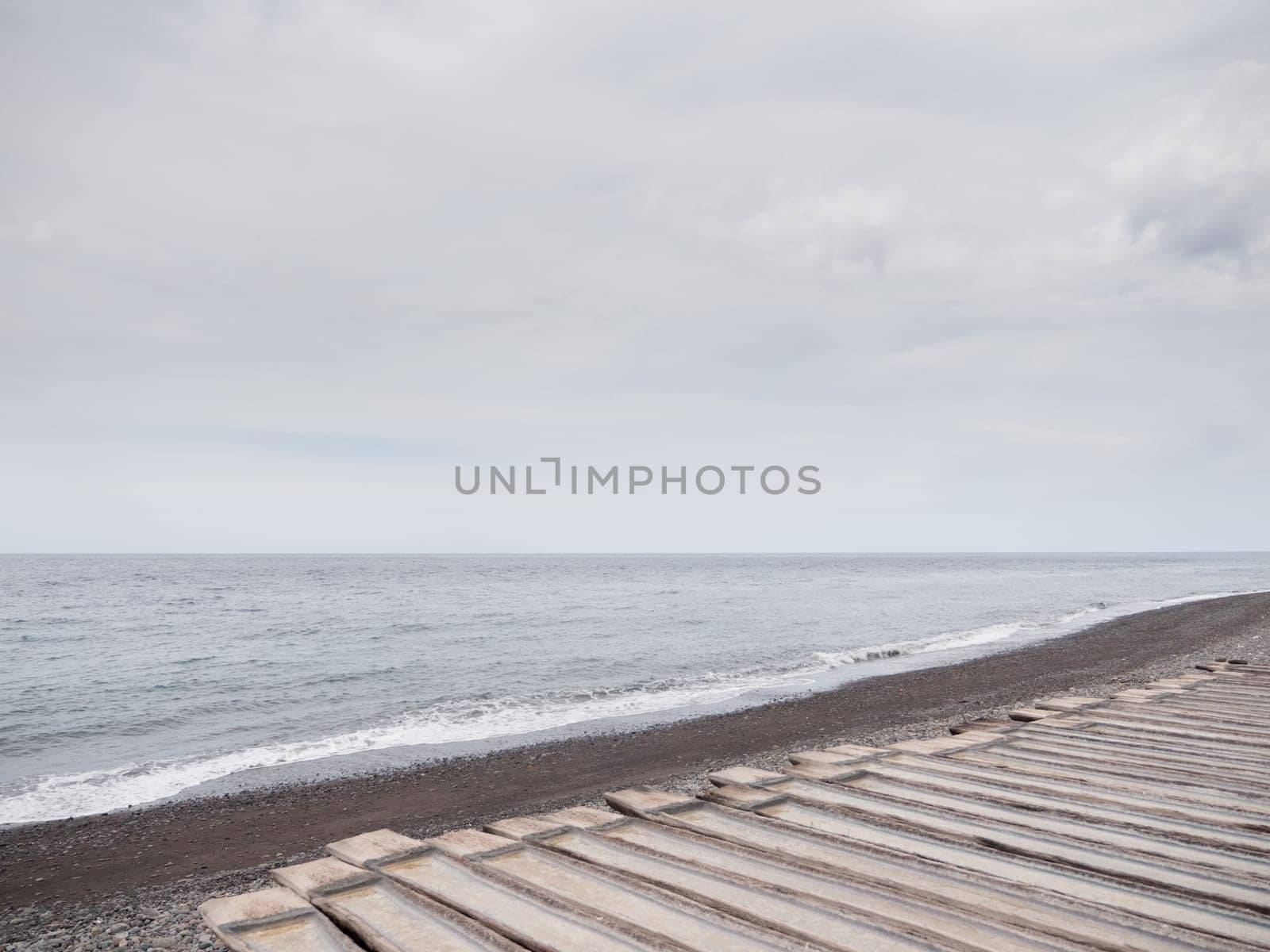 Production of sea salt in the Bali,Indonesia. Salt crystallizes out of the ground in salt farm, filled with natural salt from the sea.