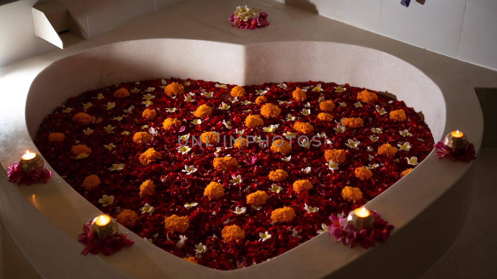 heart shaped bath with petals tropical flowers. Luxury spa. Rest body and soul.Beauty Style. Romantic gift for Valentine's Day.