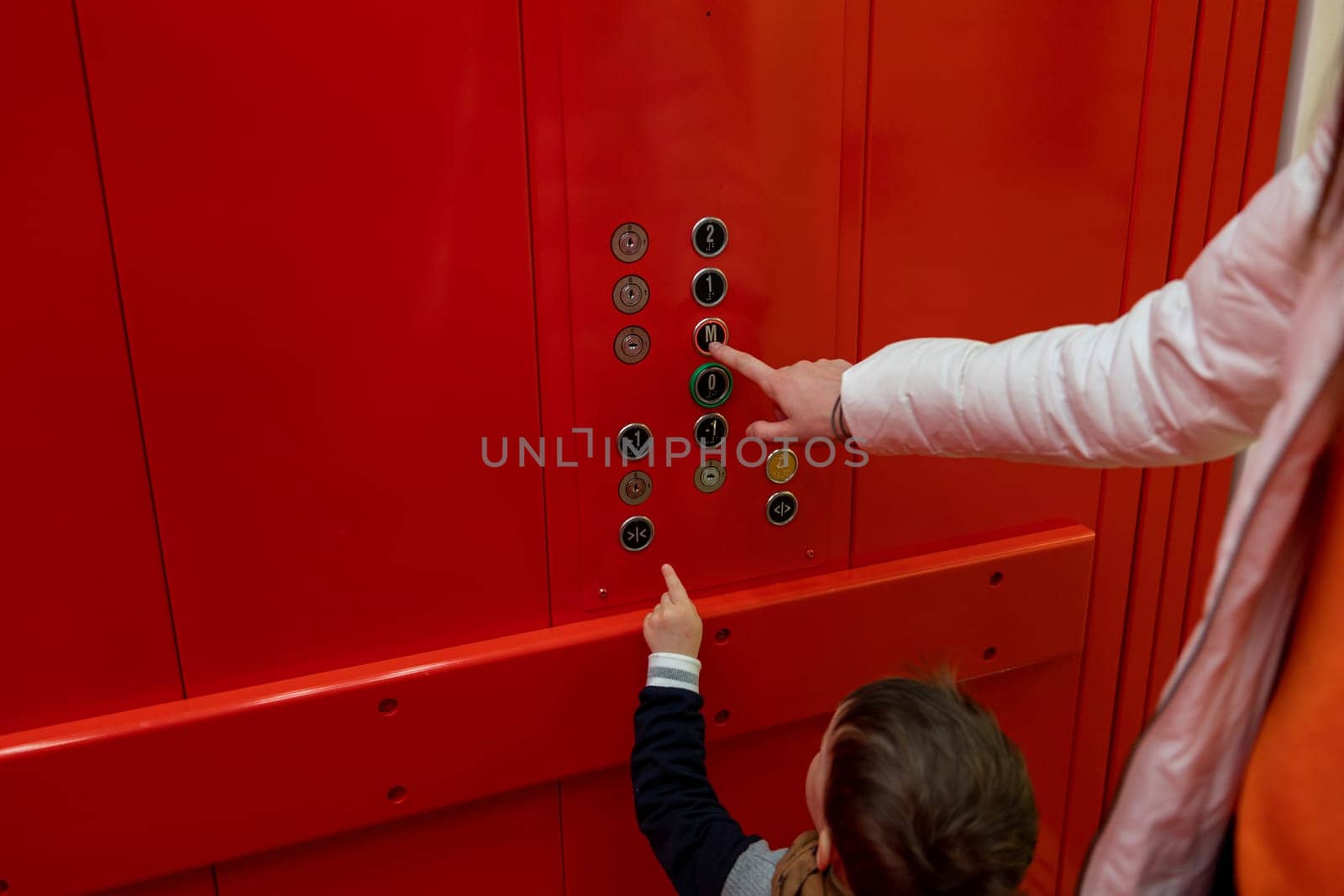 small boy pressing button in red elevator. High quality photo