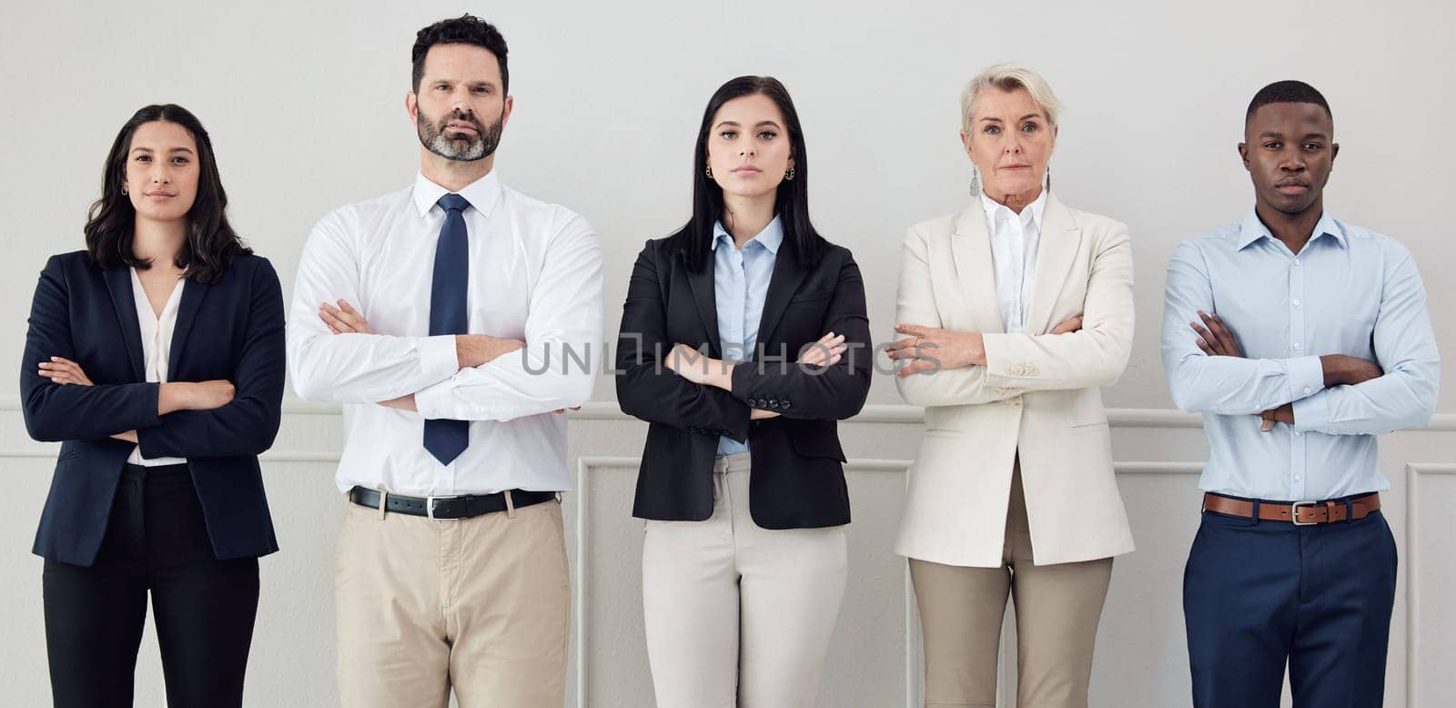 Portrait, professional and arms crossed with a business team standing together in a corporate office. Collaboration, teamwork and management with a group of serious people looking confident at work by YuriArcurs