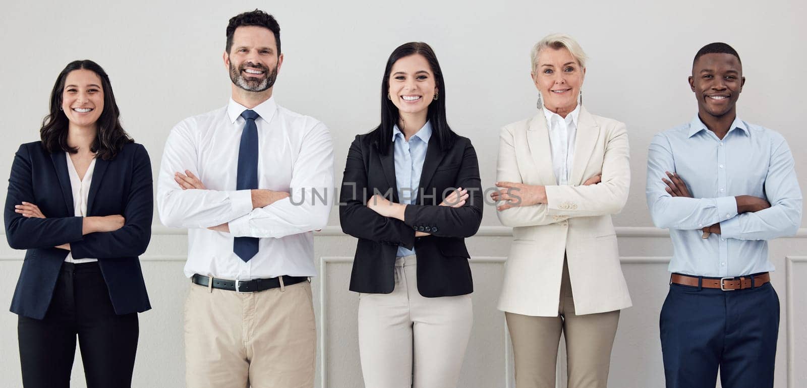 Portrait, collaboration and arms crossed with a diverse leadership team standing in their professional office. Business, teamwork and management with a group of colleagues looking confident at work.