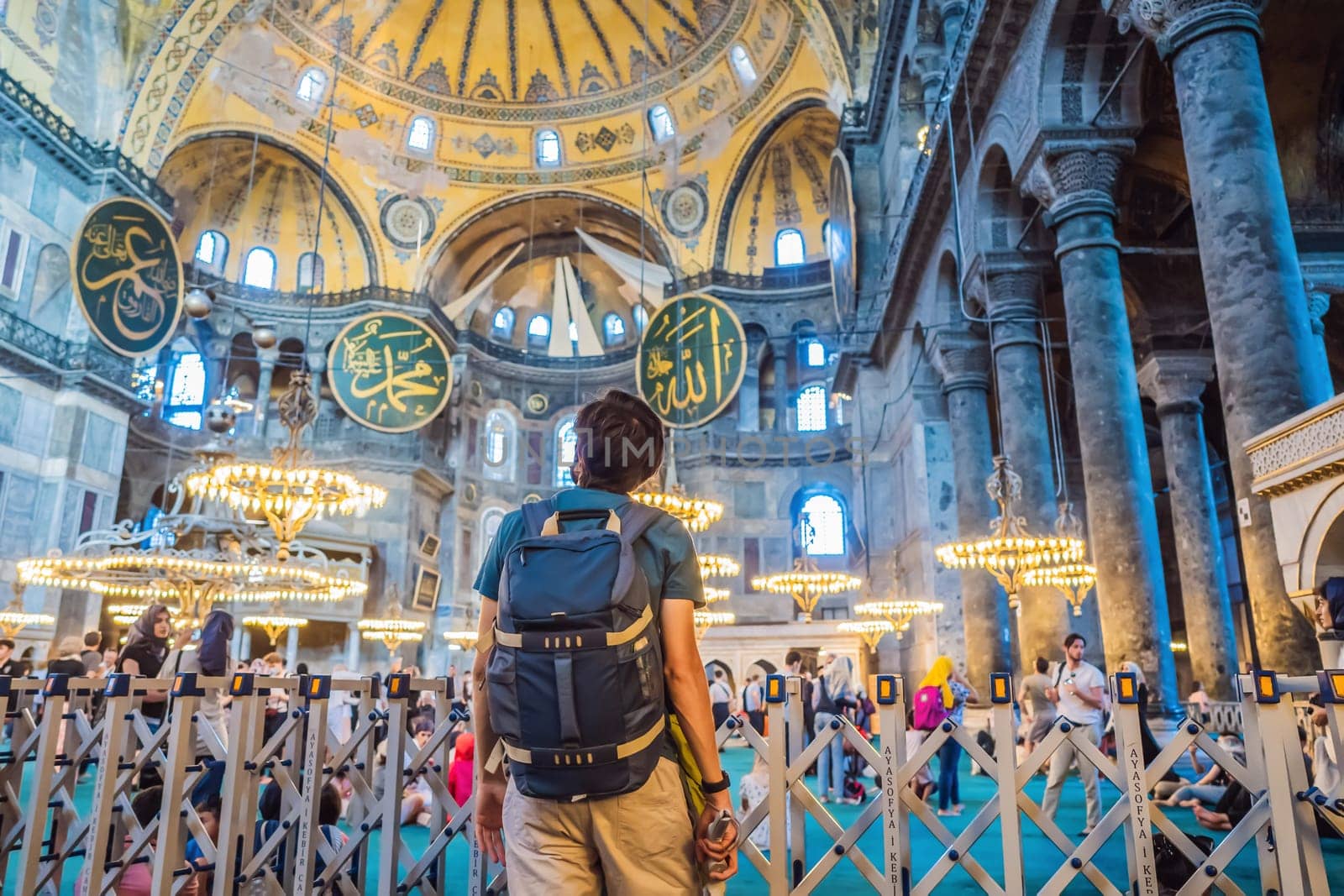 INSCRIPTION - denoting the names of Allah, the Prophet Muhammad, as well as the first 4 caliphs Man tourist enjoying Hagia Sofia, Ayasofya interior in Istanbul, Turkey, Byzantine architecture, city landmark and architectural world wonder. Turkiye.
