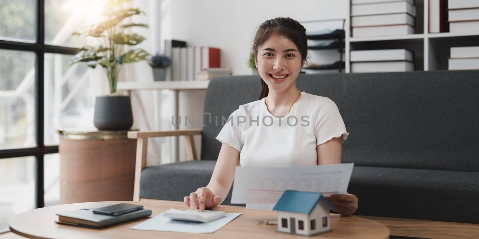 Asian accounting professional calculating household bills, reviewing and analyzing household bills, and filing tax returns.