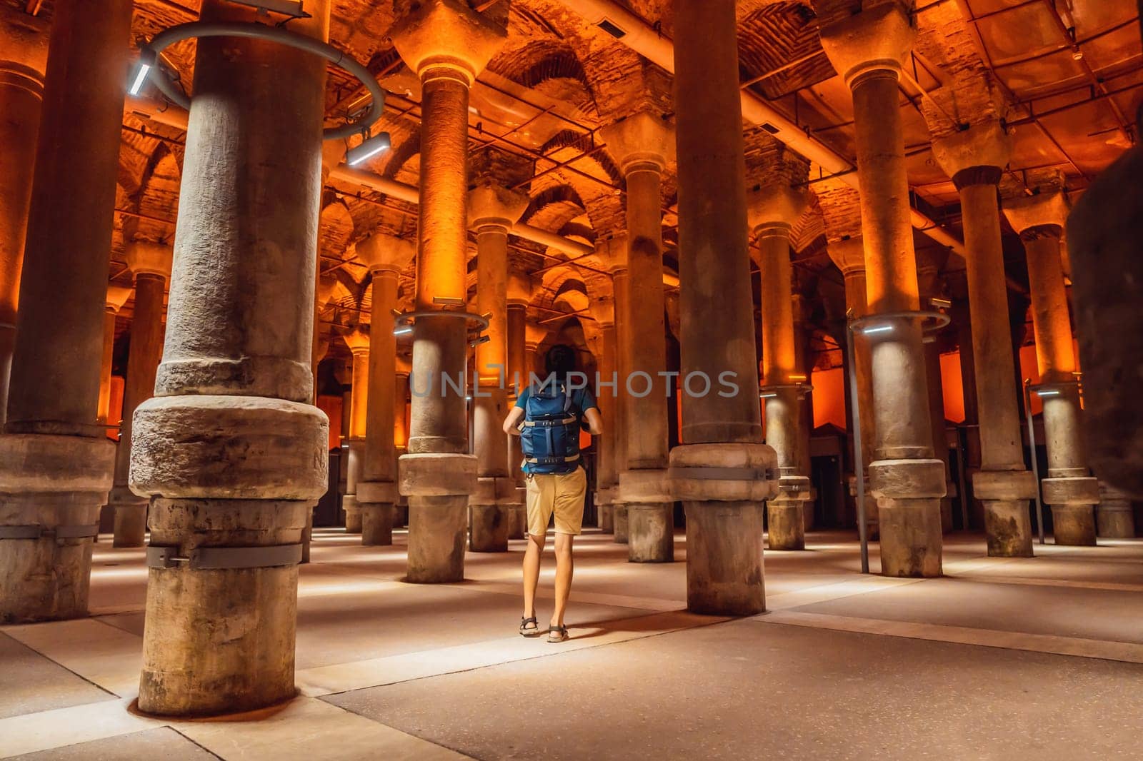 Man tourist enjoying Beautiful cistern in Istanbul. Cistern - underground water reservoir build in 6th century, Istanbul, Turkey, Turkiye.