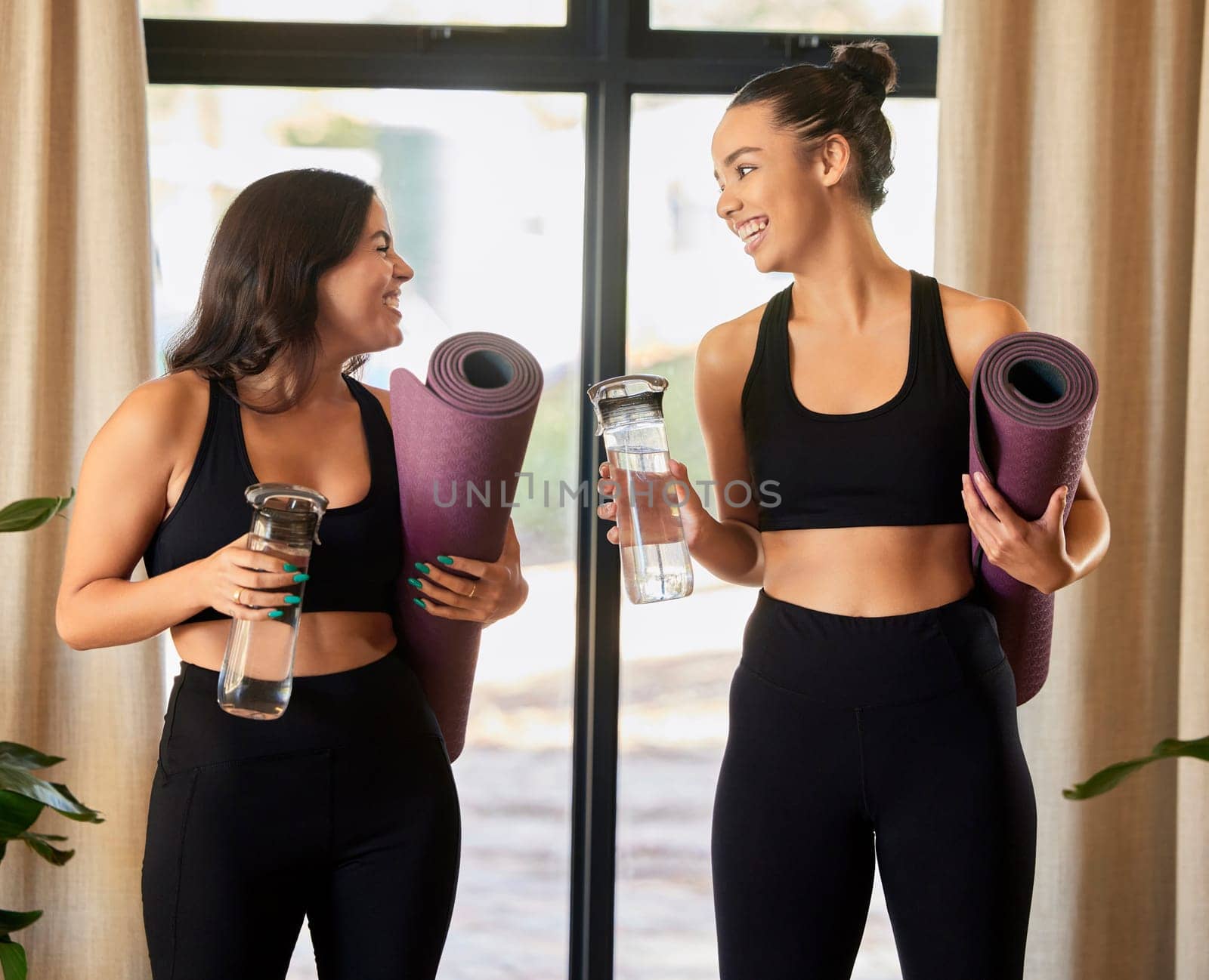 Women or friends talking in yoga class in training gear for fitness, exercise or sports teamwork and wellness. Pilates, meditation and healthy gen z or young people chat of holistic workout together by YuriArcurs