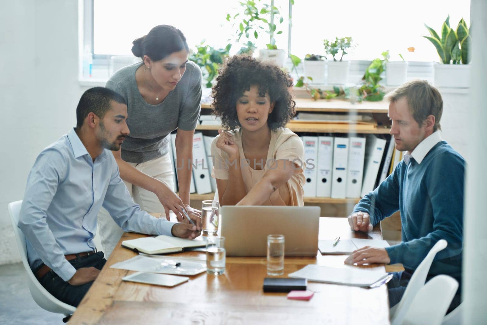 Failure is no option for this team. Shot of a group of professionals using wireless technology during a meeting. by YuriArcurs