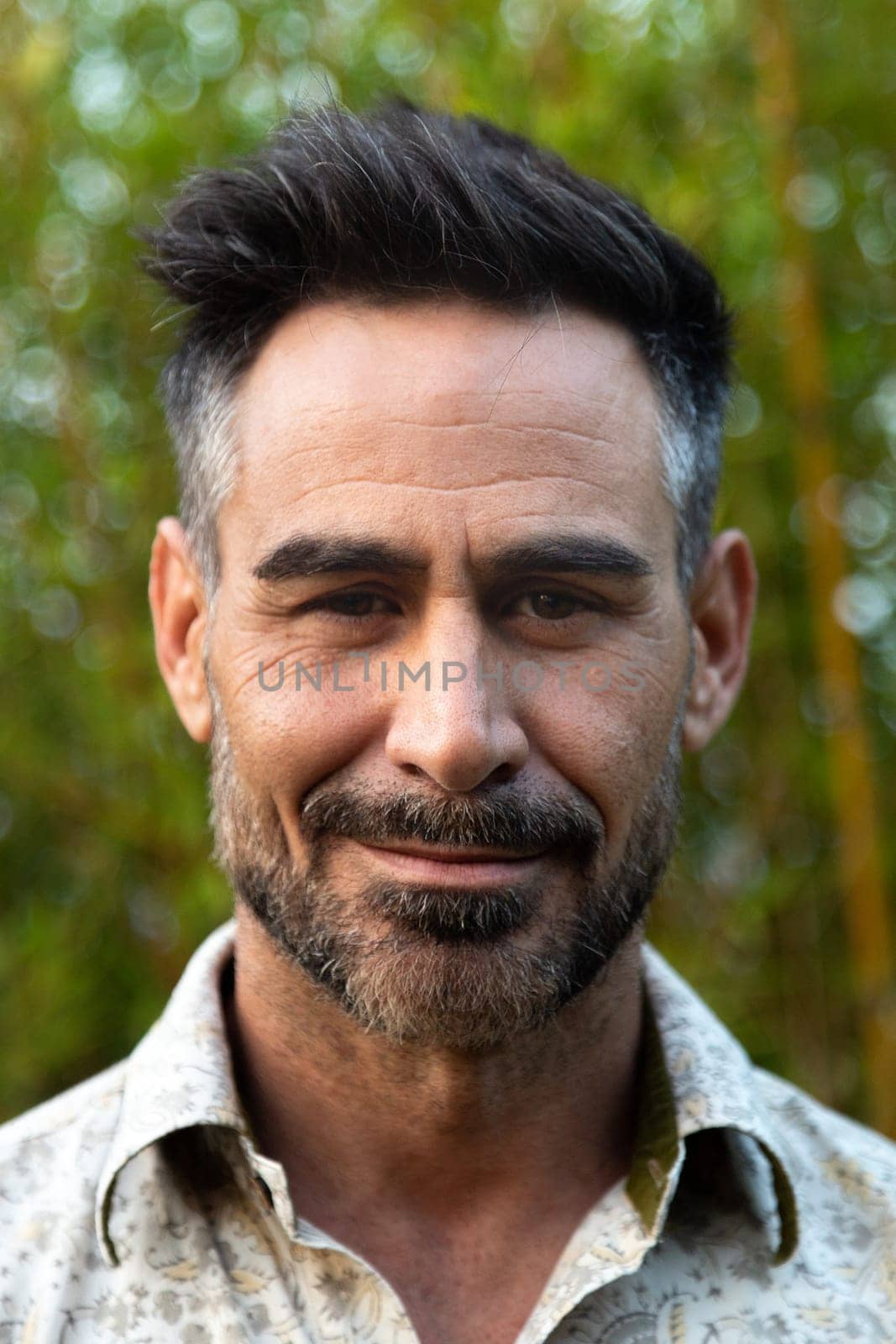 Vertical headshot of middle age white man with beard in nature. Lifestyle.