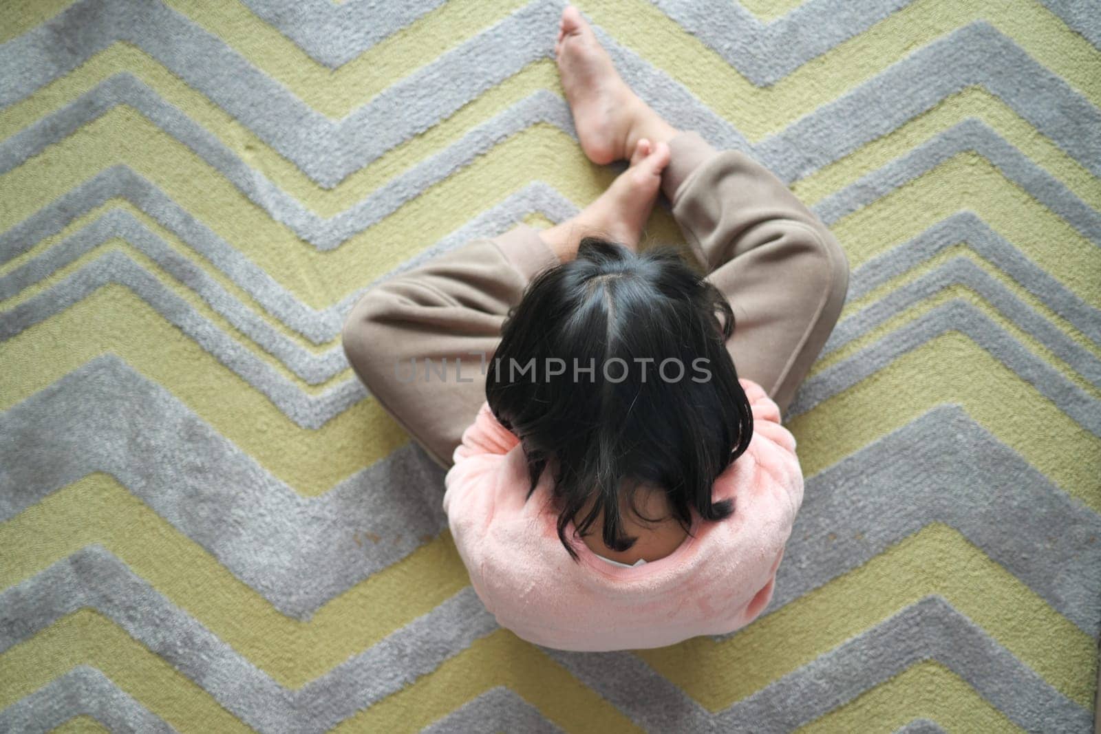 a upset child girl cover her face with hand .