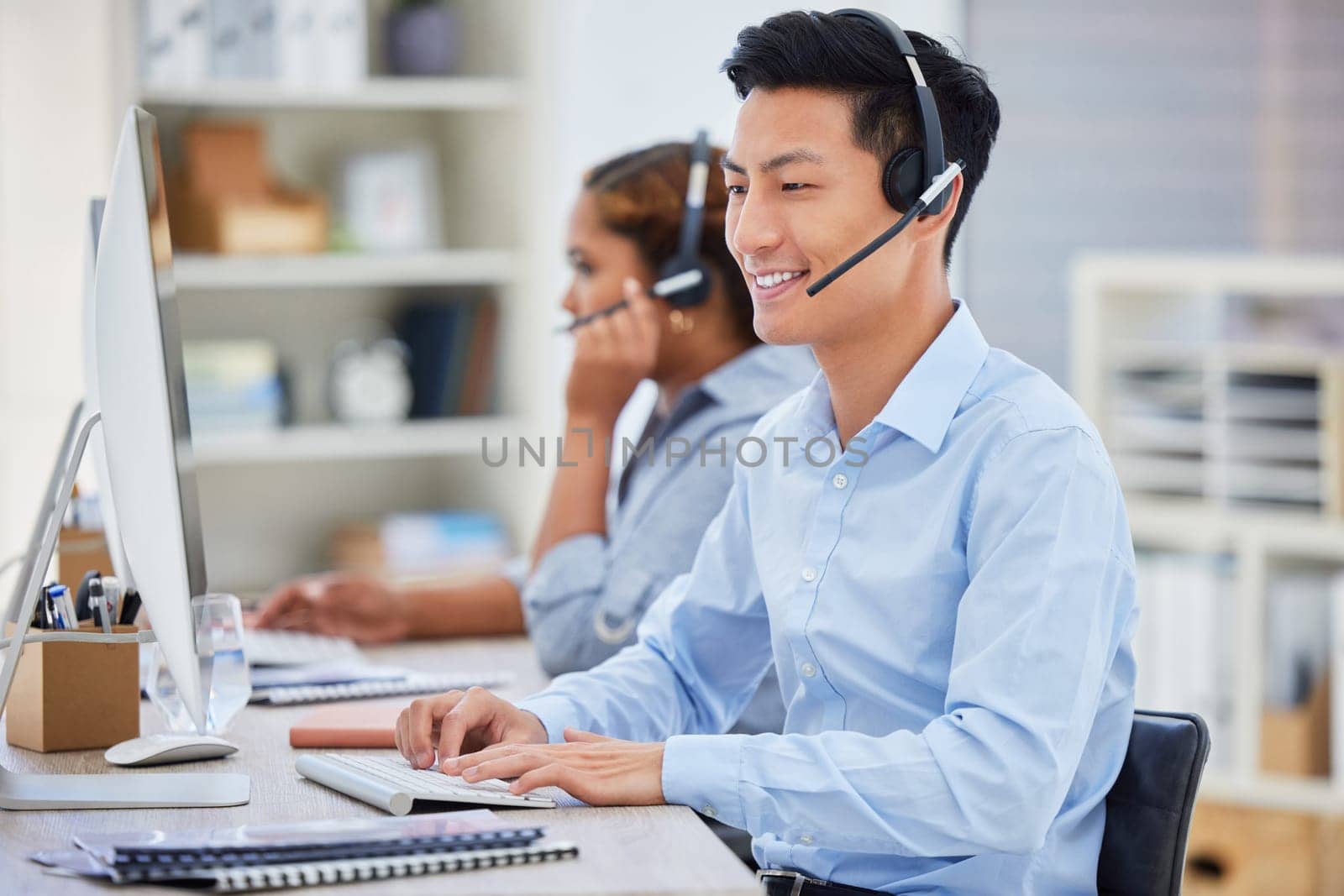 Business man, telemarketing and call center consultation in a office working on a computer. Smile, male worker and web support advice of a contact us employee with professional communication at job.