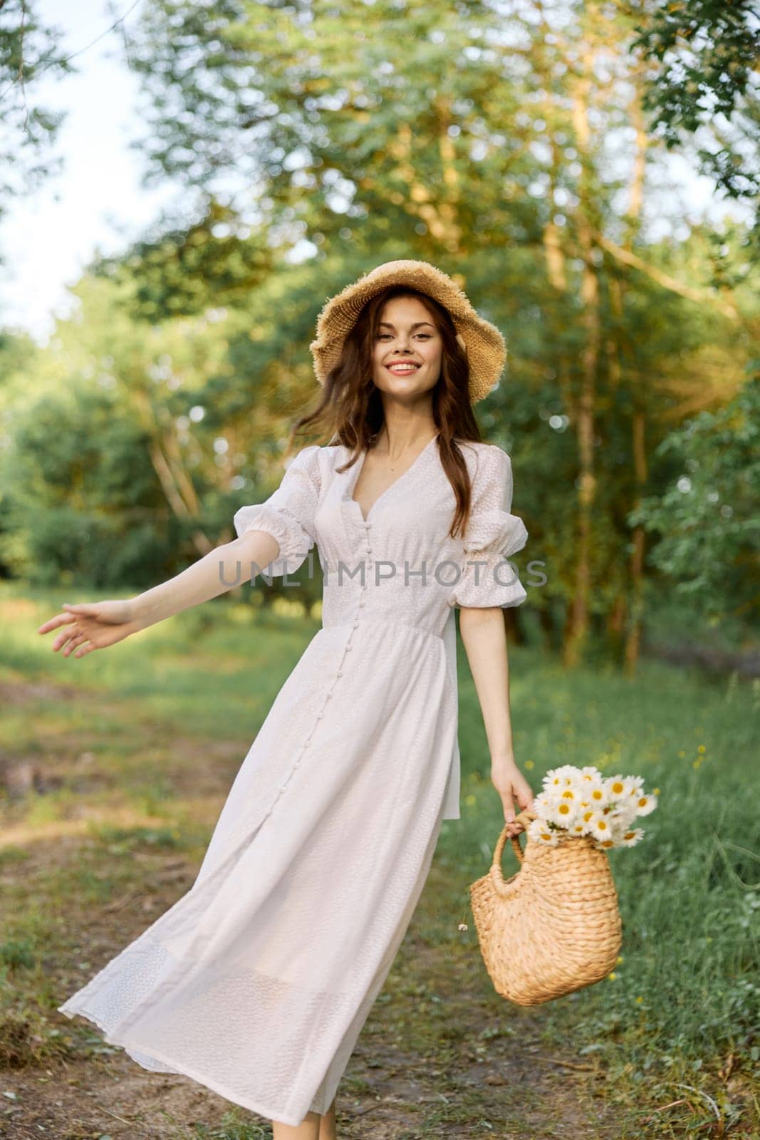 happy woman in a light dress smiles joyfully walking through the forest. High quality photo