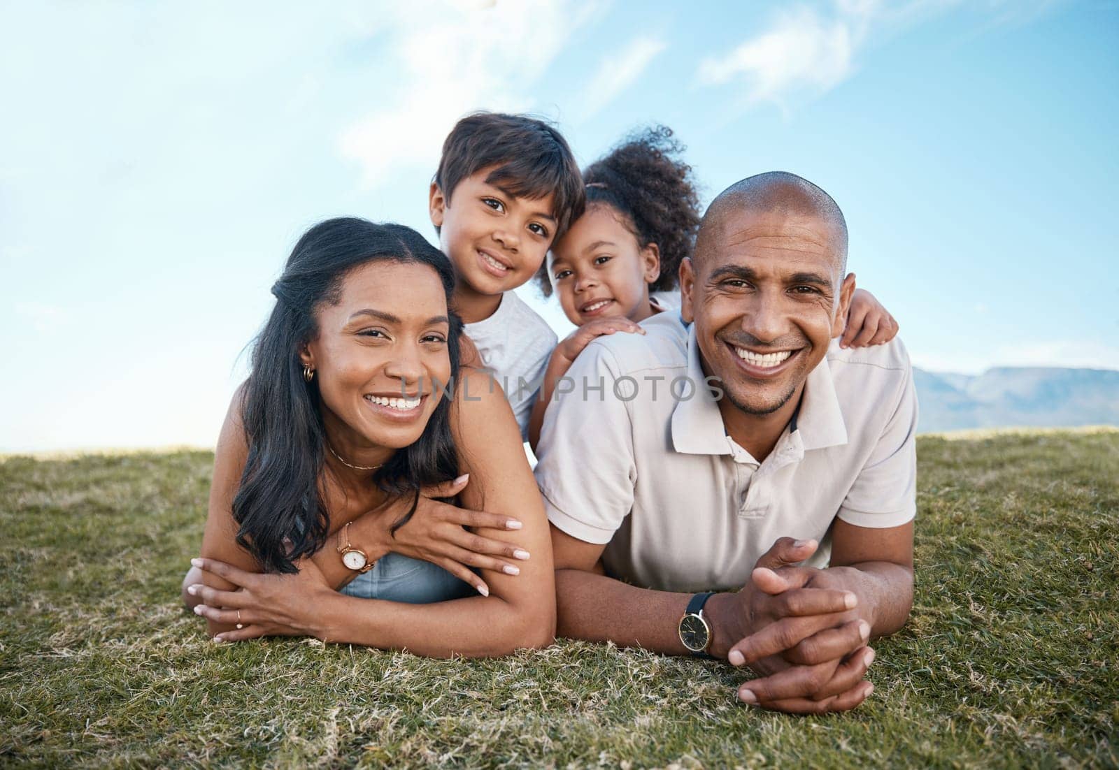 Family, portrait and relax parents in garden with mother, father and kids together with love. Face, top view and dad with mom and children with parent support and care on a lawn with happy smile by YuriArcurs