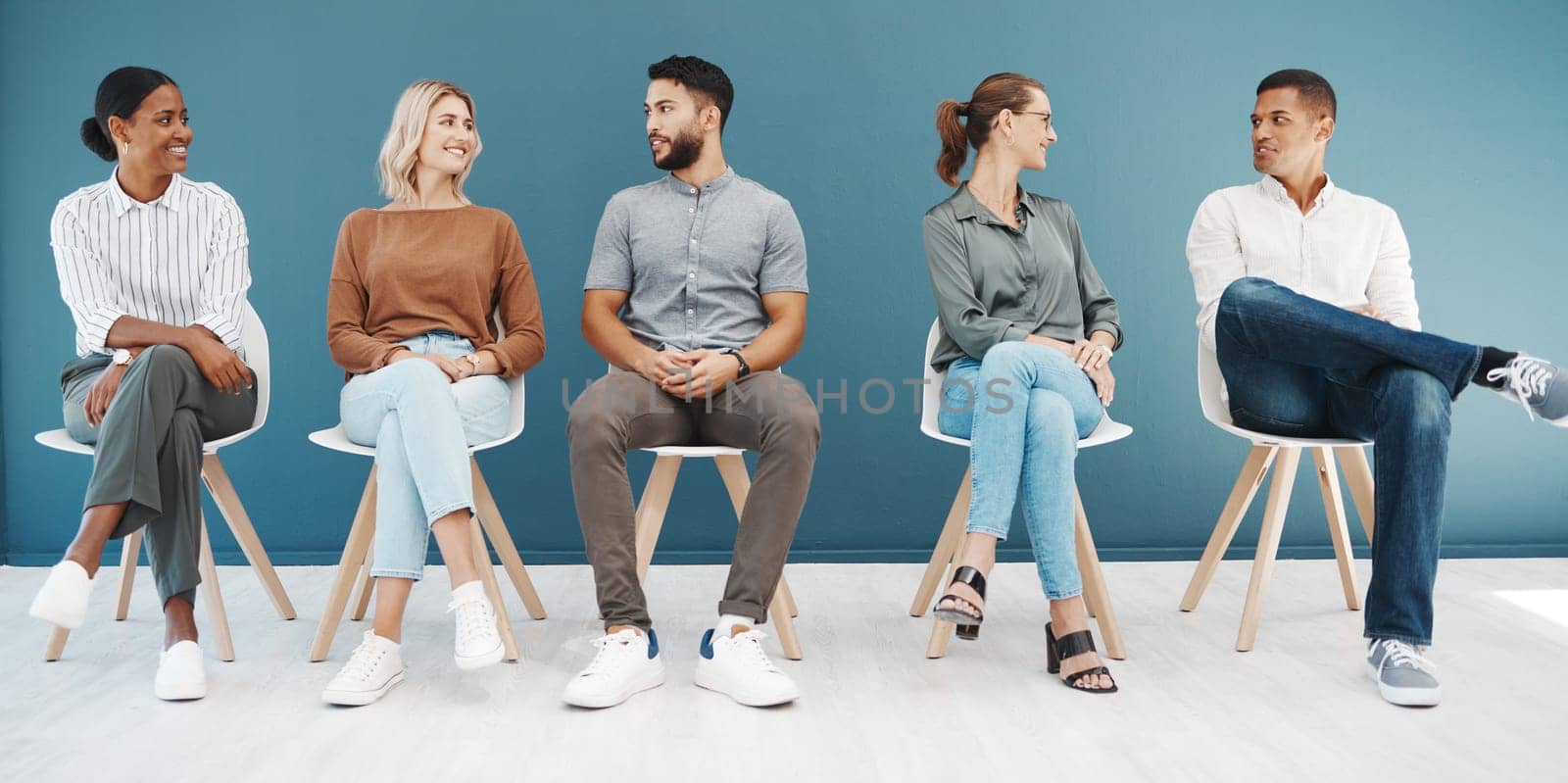 Interview queue, business people and talk by wall with smile, diversity and waiting room for hr recruitment. Men, women and happy together for interview, human resources and hiring for job at startup.