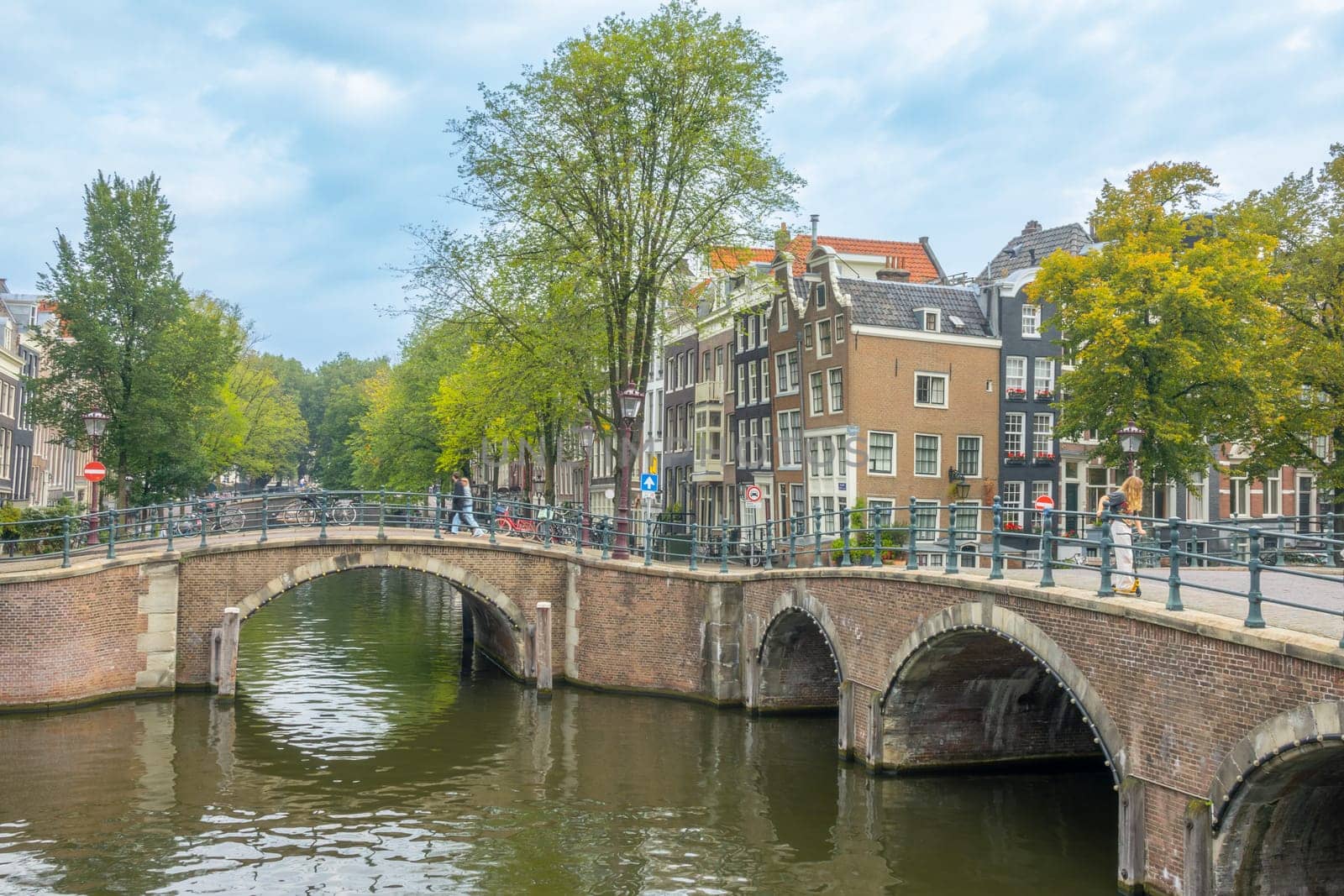 Netherlands. Old stone bridges on the Amsterdam canals. Typical Dutch houses with dancing facades on the quay