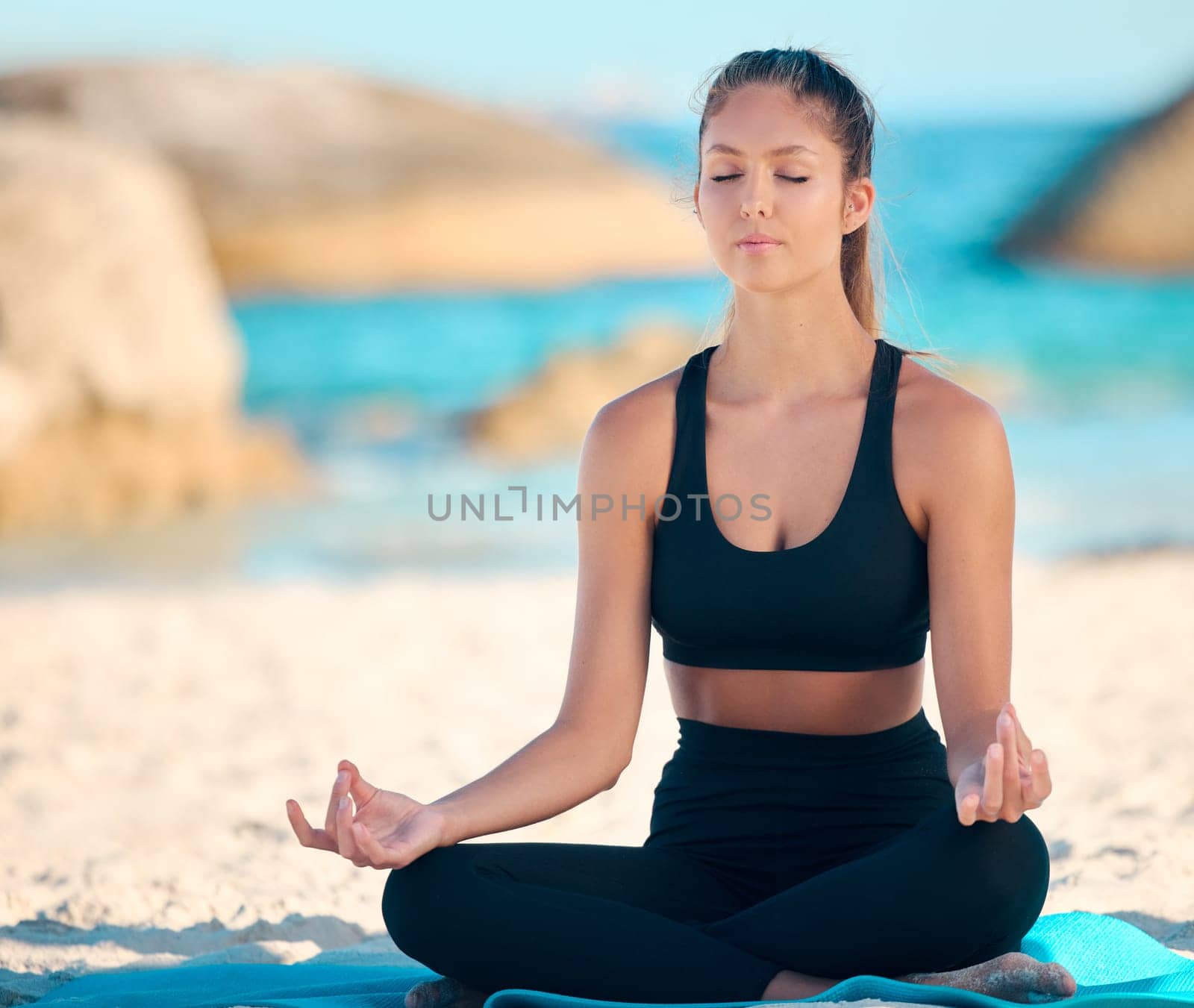 Yoga, calm and meditate on the beach with zen on a mat for wellness in cape town for workout. Ocean, balance and yogi with peace with lotus in summer for fitness with mental health and freedom