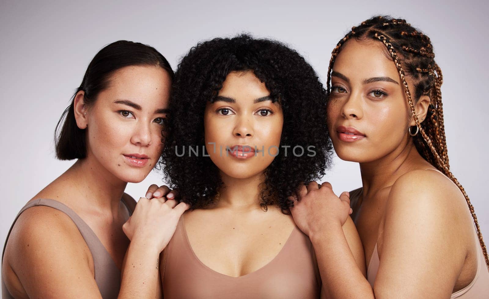 Portrait, makeup and diversity with woman friends in studio on a gray background together for skincare. Face, beauty and natural with a female model group posing to promote support or inclusion.