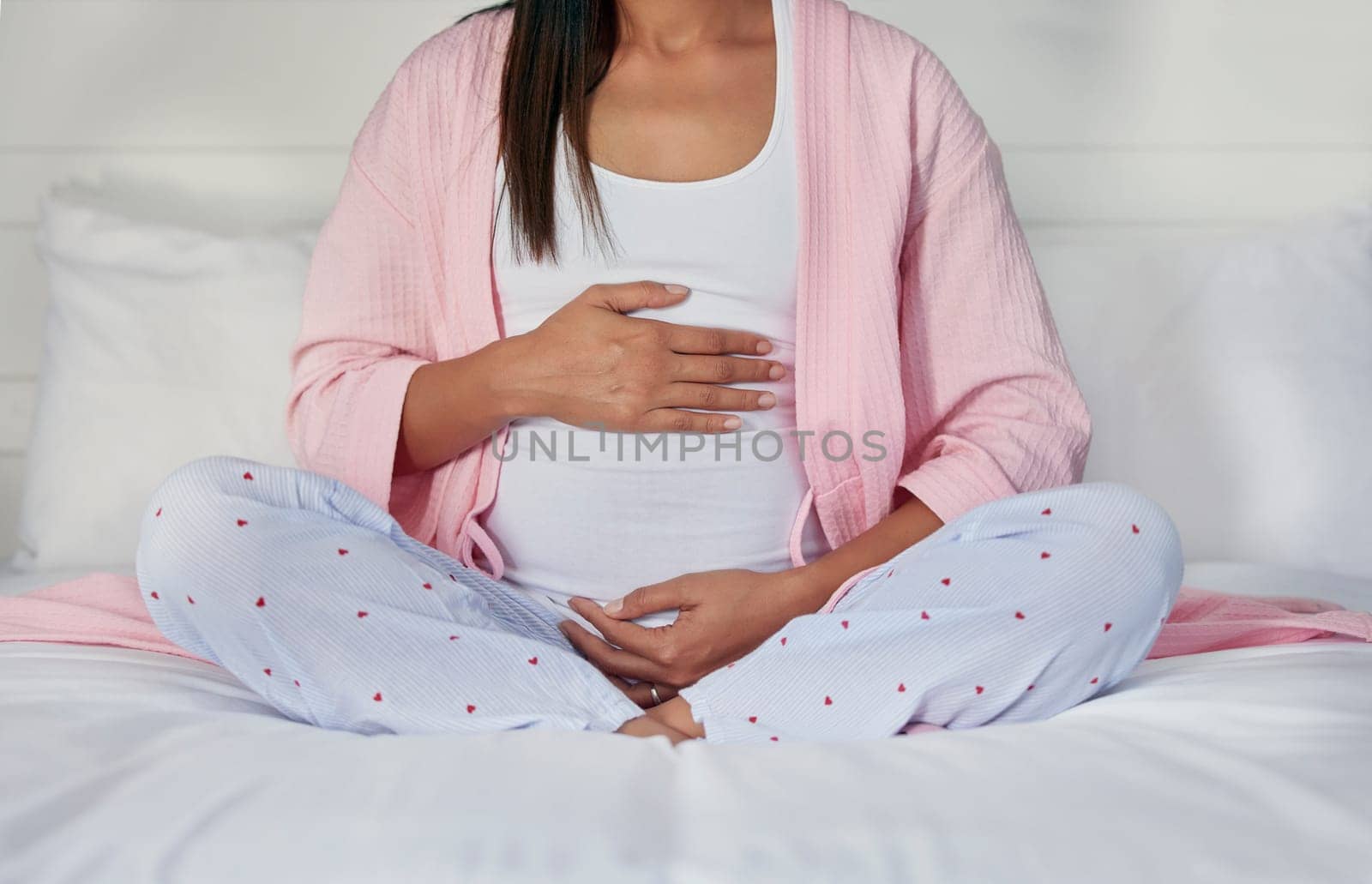 Pregnant, hands on stomach and woman in bed holding belly for baby, infant and affection at home. Pregnancy love, family and excited, loving and happy mother rest, relaxing and calm in bedroom by YuriArcurs