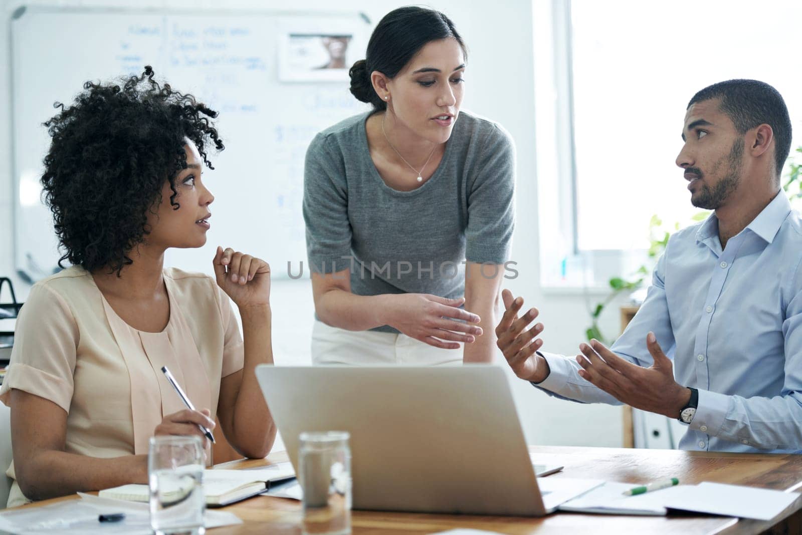 Talking their way to innovative concepts. Shot of a group of professionals using wireless technology during a meeting. by YuriArcurs