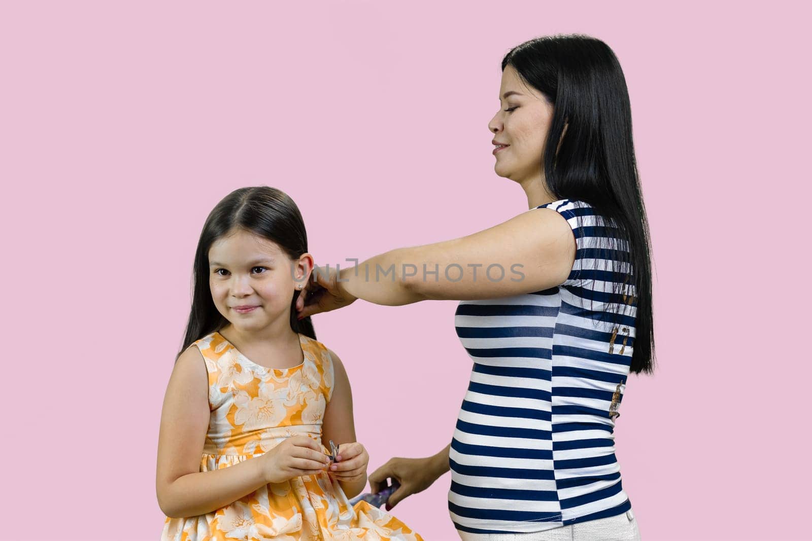 Young brunette mother is combing hair of her little daughter. by super_picture