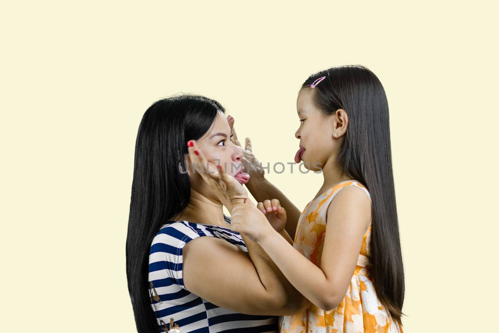 Side view of woman and little girl are making faces to each other. by super_picture