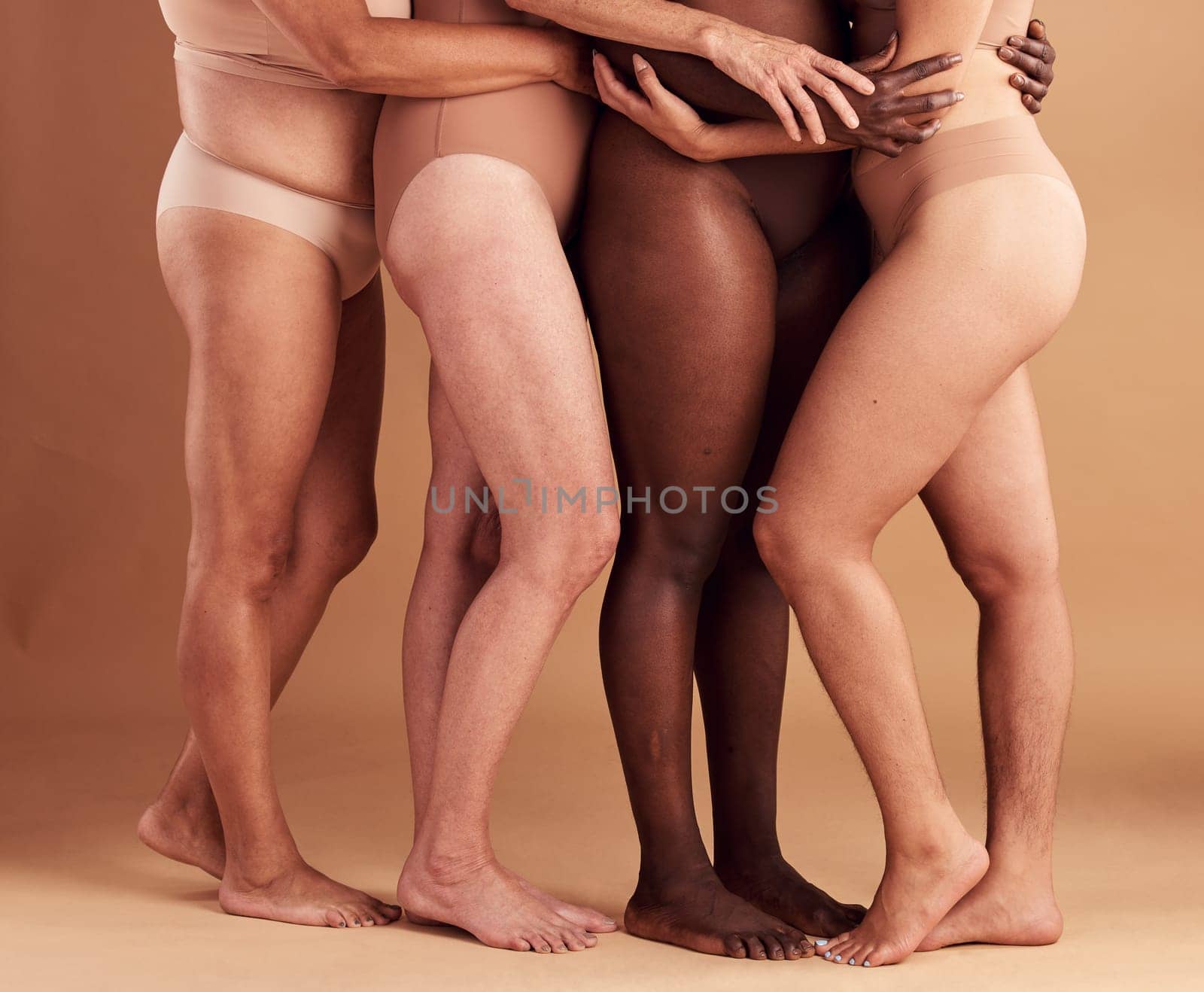 Diversity, legs and body positivity, women in underwear huddle together on studio background. Feet, friends and health, empowerment in self love and care in global community of diverse female bodies