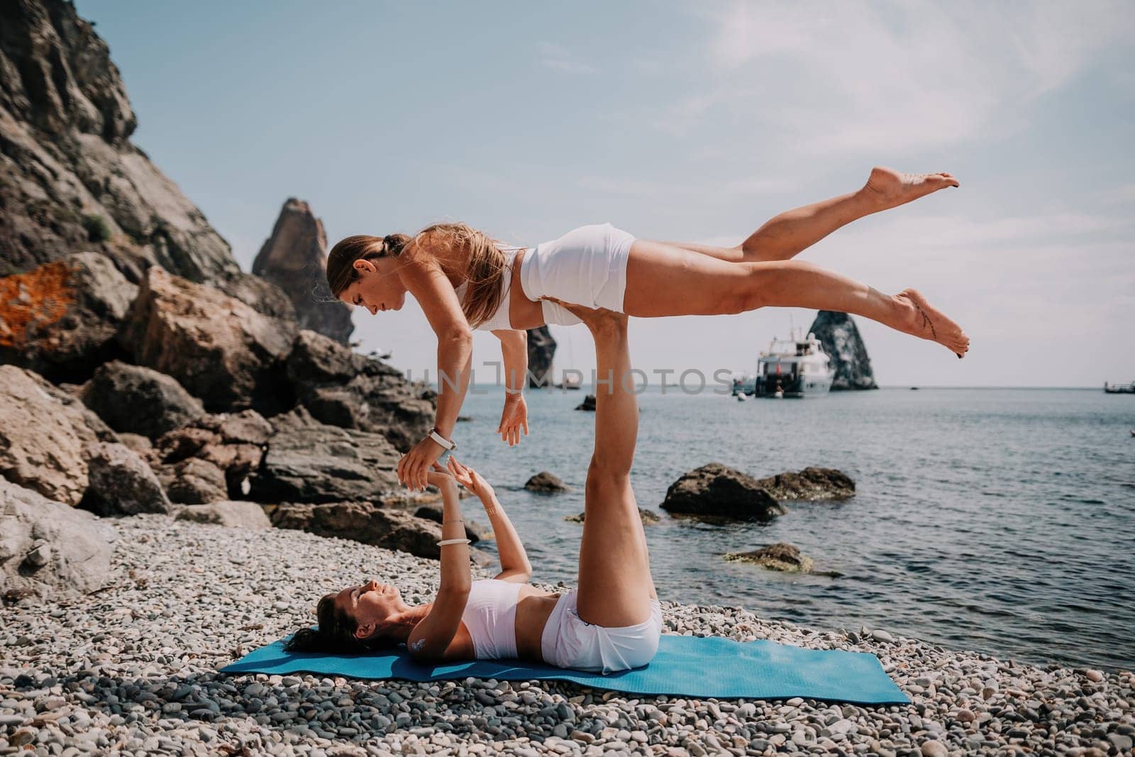 Woman sea yoga. Back view of free calm happy satisfied woman with long hair standing on top rock with yoga position against of sky by the sea. Healthy lifestyle outdoors in nature, fitness concept.