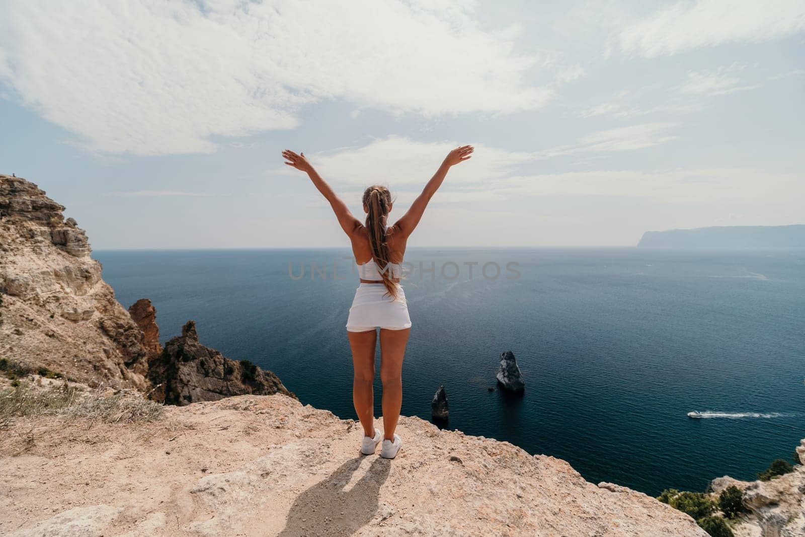 Woman travel sea. Young Happy woman posing on a beach over the sea on background of volcanic rocks, like in Iceland, sharing travel adventure journey by panophotograph
