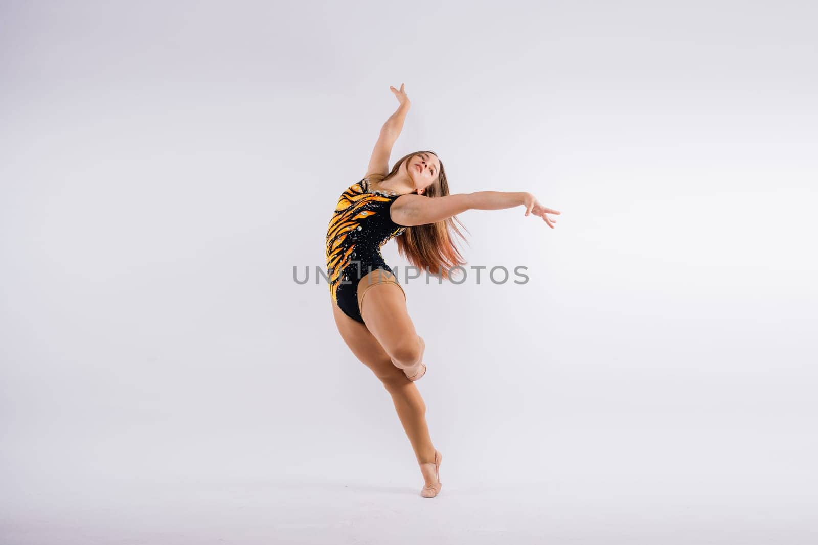 Young beautiful dancer posing on studio background with copy space