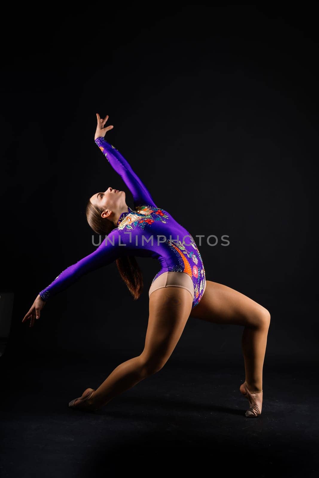 Young beautiful dancer posing on a studio background with copy space by Zelenin