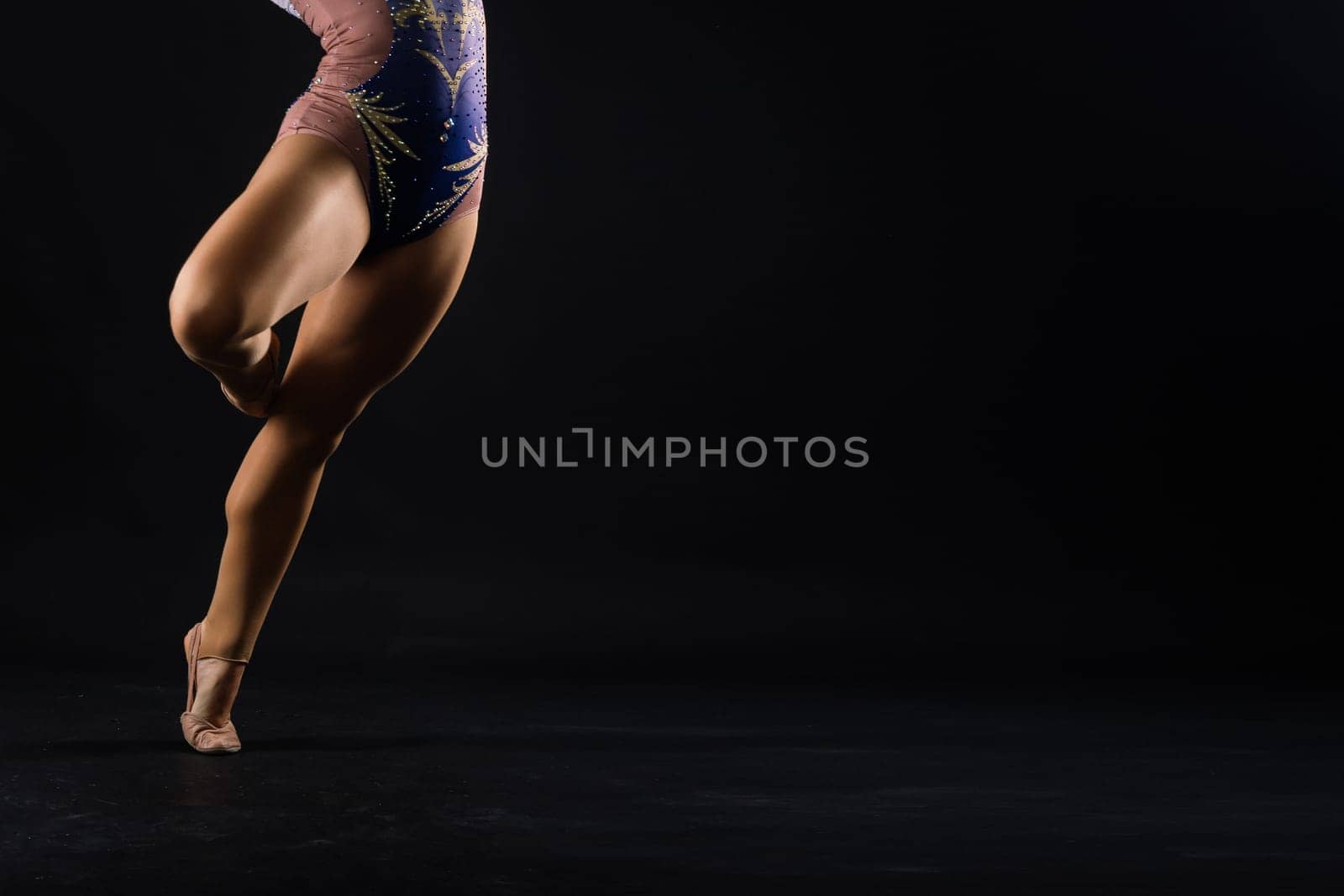 Young beautiful dancer posing on studio background with copy space