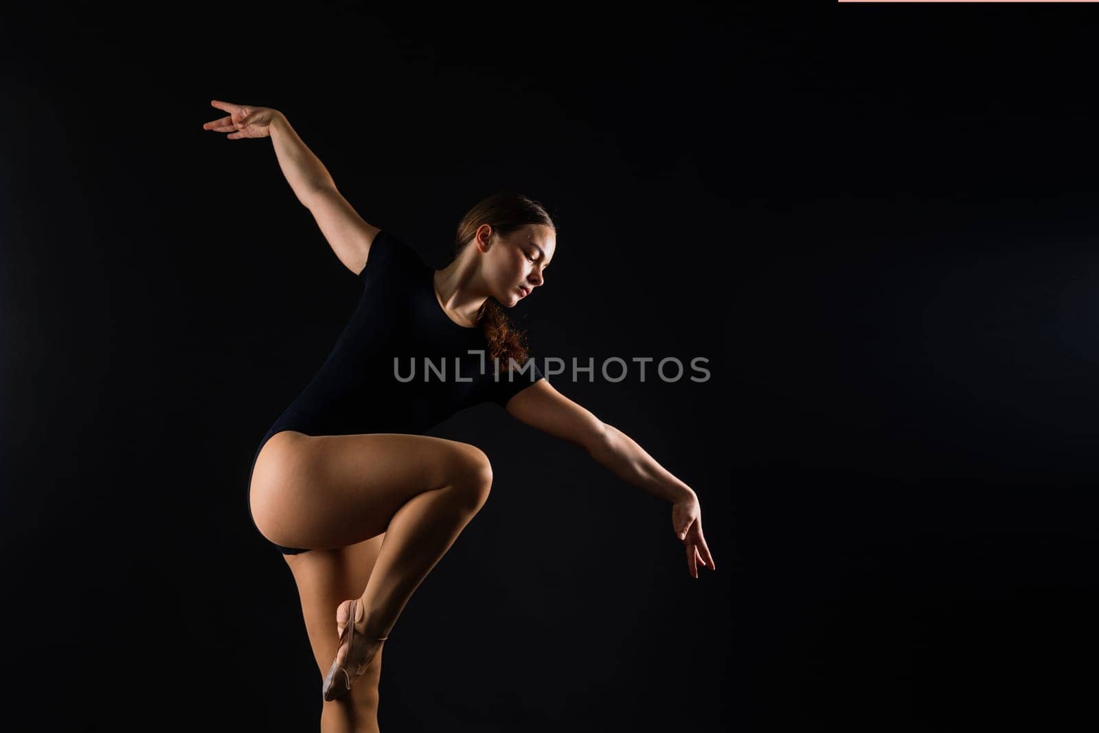 Young beautiful dancer posing on a studio background with copy space by Zelenin