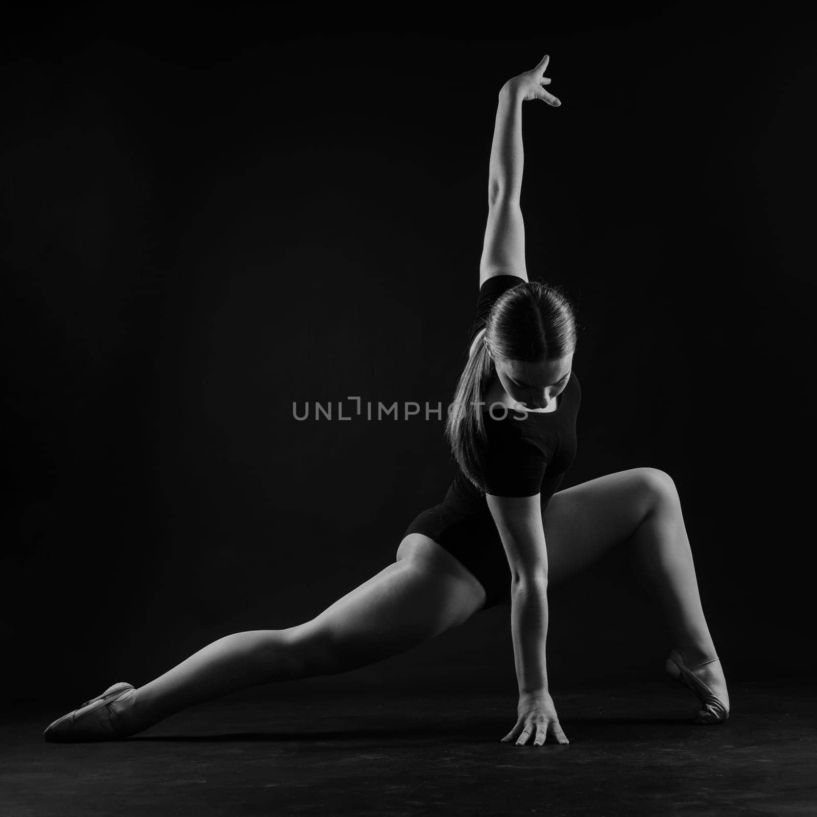 Young beautiful dancer posing on studio background with copy space