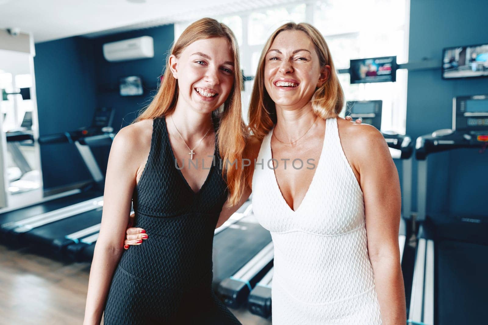 Portrait of a teen girl with her mother training together in a sports gym