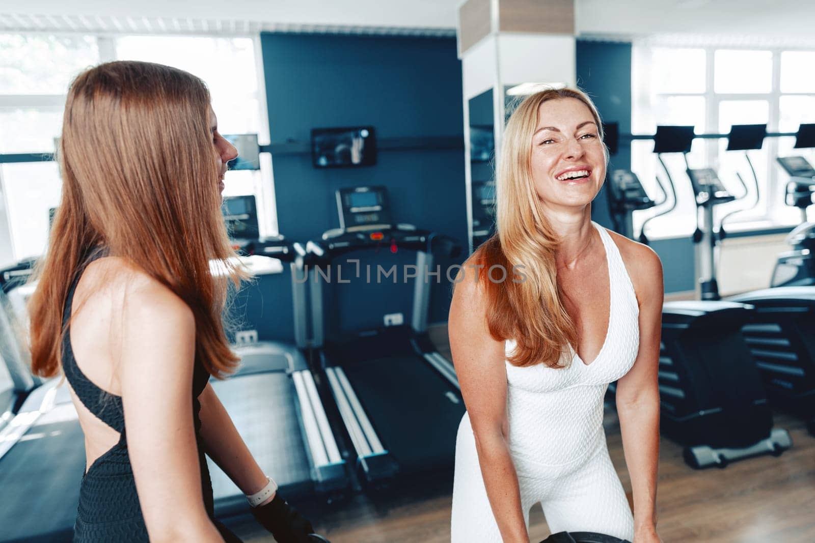 Portrait of a teen girl with her mother training together in a gym by Fabrikasimf