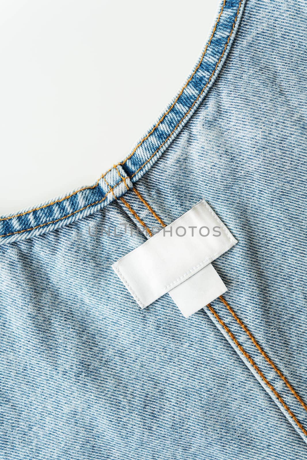 White label on denim clothes with size and brand, place for writing, mockup. Close-up. by sfinks