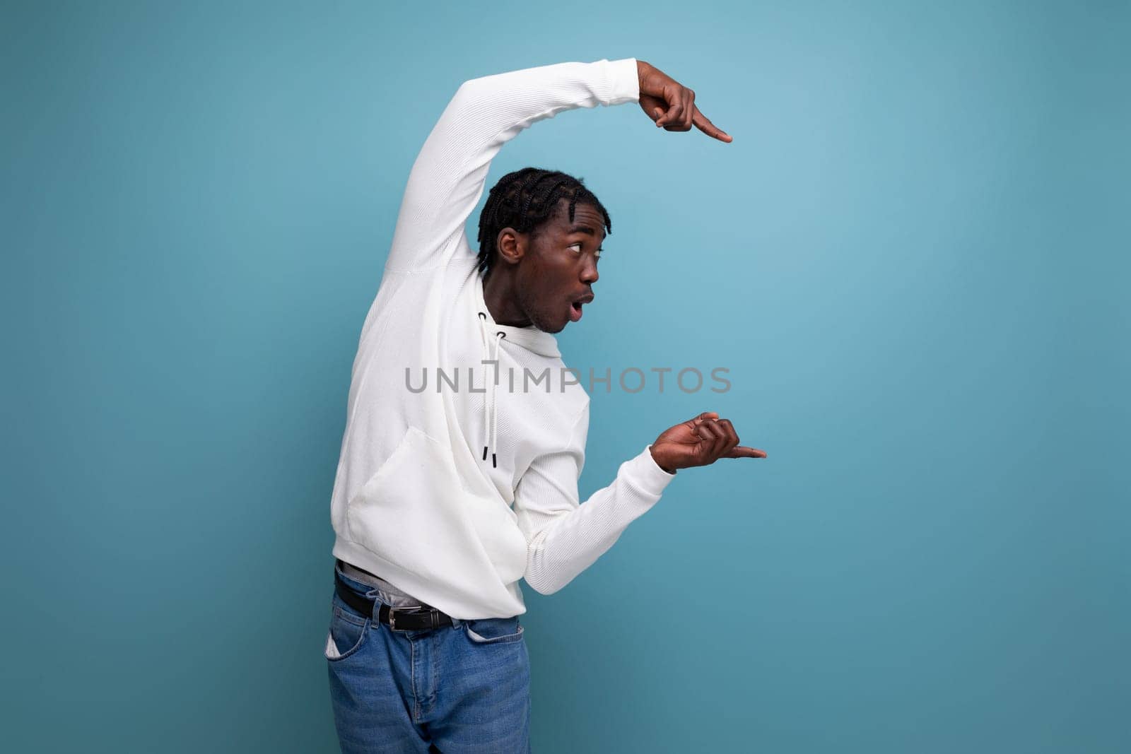 inspired man young brunet african man shows with hand to advertisement offer on blue isolated background by TRMK