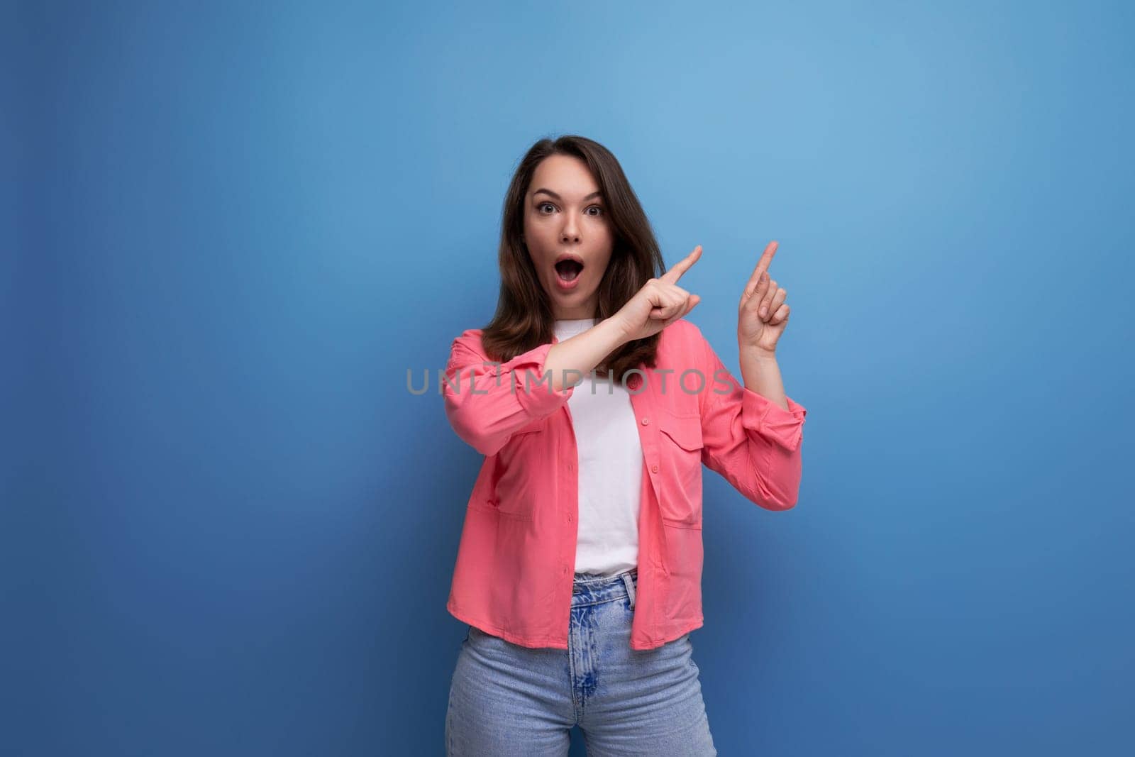 surprised brunette young woman in casual outfit smiling over isolated background.