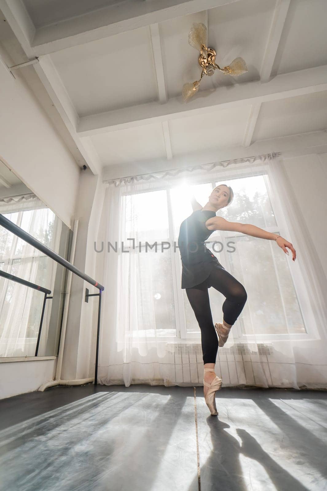 A beautiful Asian woman is dancing at the barre. Ballet dancer. by mrwed54