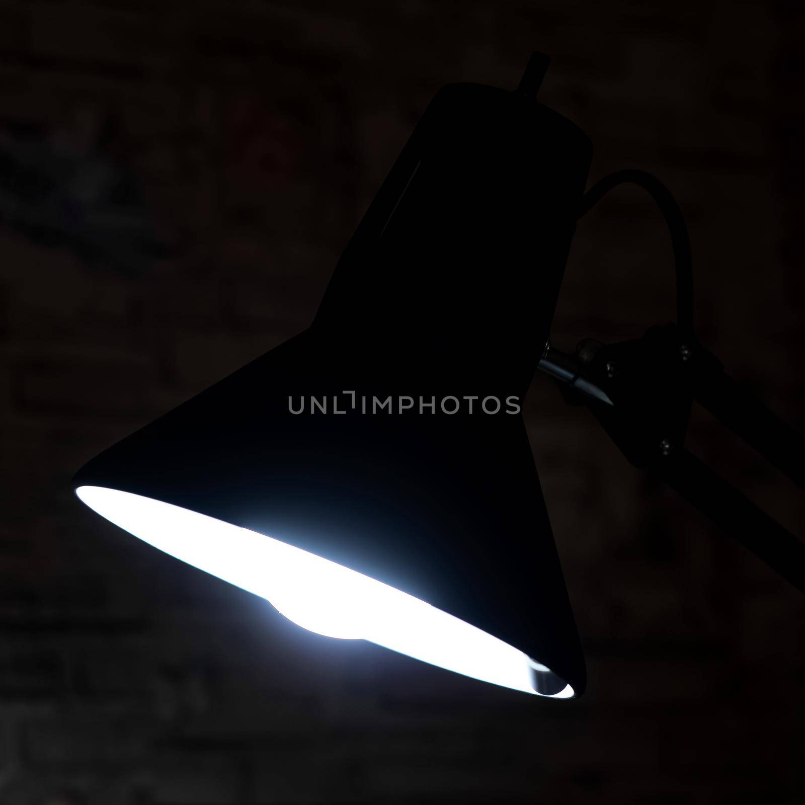 The light of a black table lamp in the dark close up