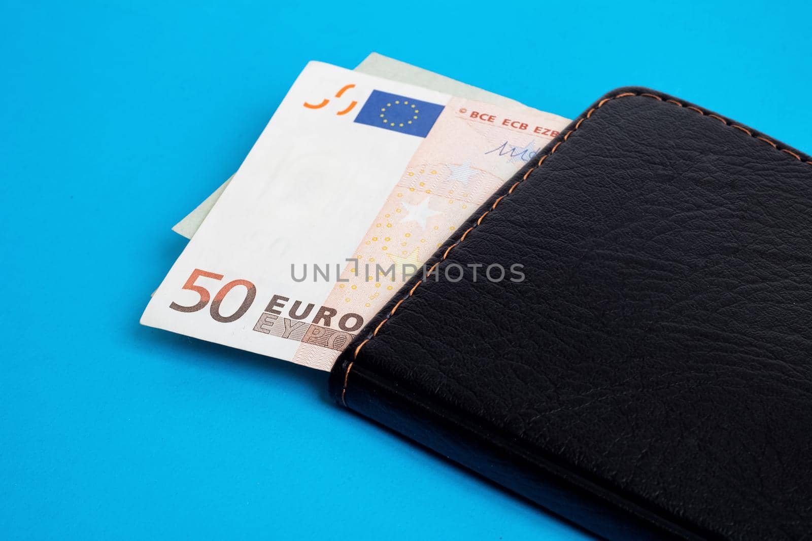 Euro in wallet on a blue background close up